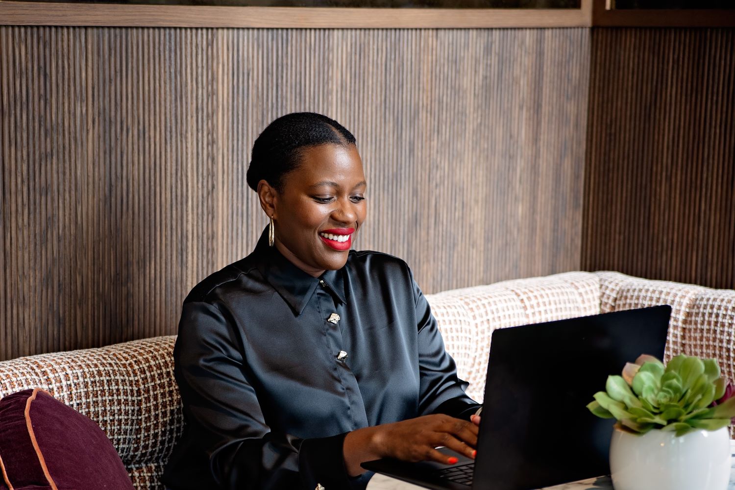 Designer Fatou Ceesay sitting at a laptop
