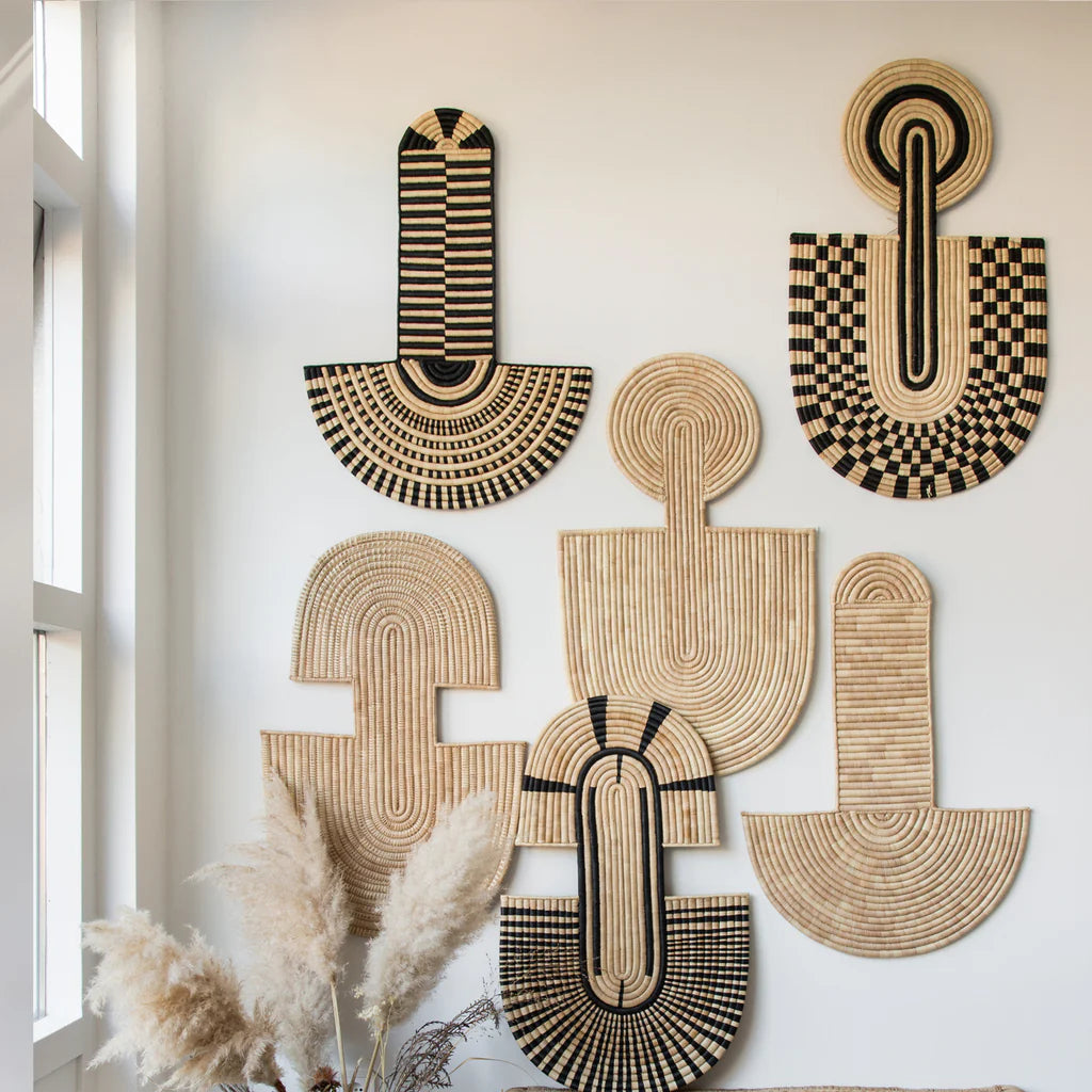Decorative wall art pieces with geometric patterns on a white wall.