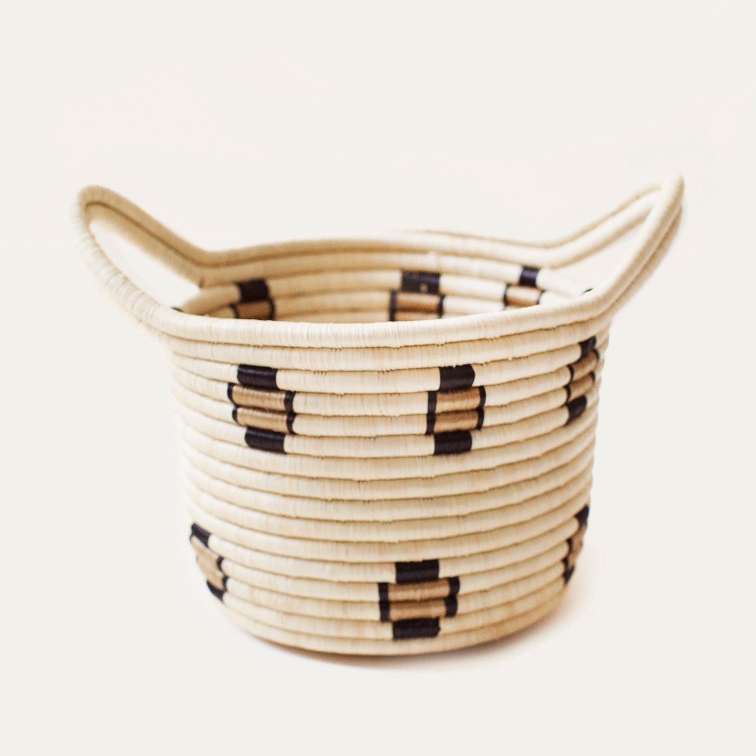 Woven basket with black patterns on a light background