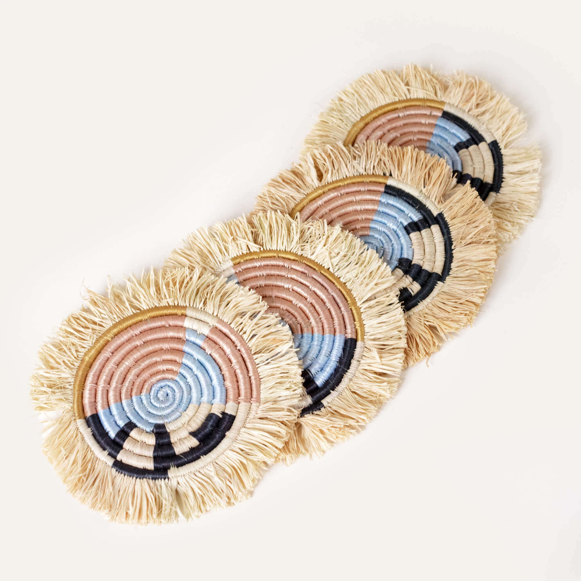 Set of four woven coasters with colorful patterns on a white background