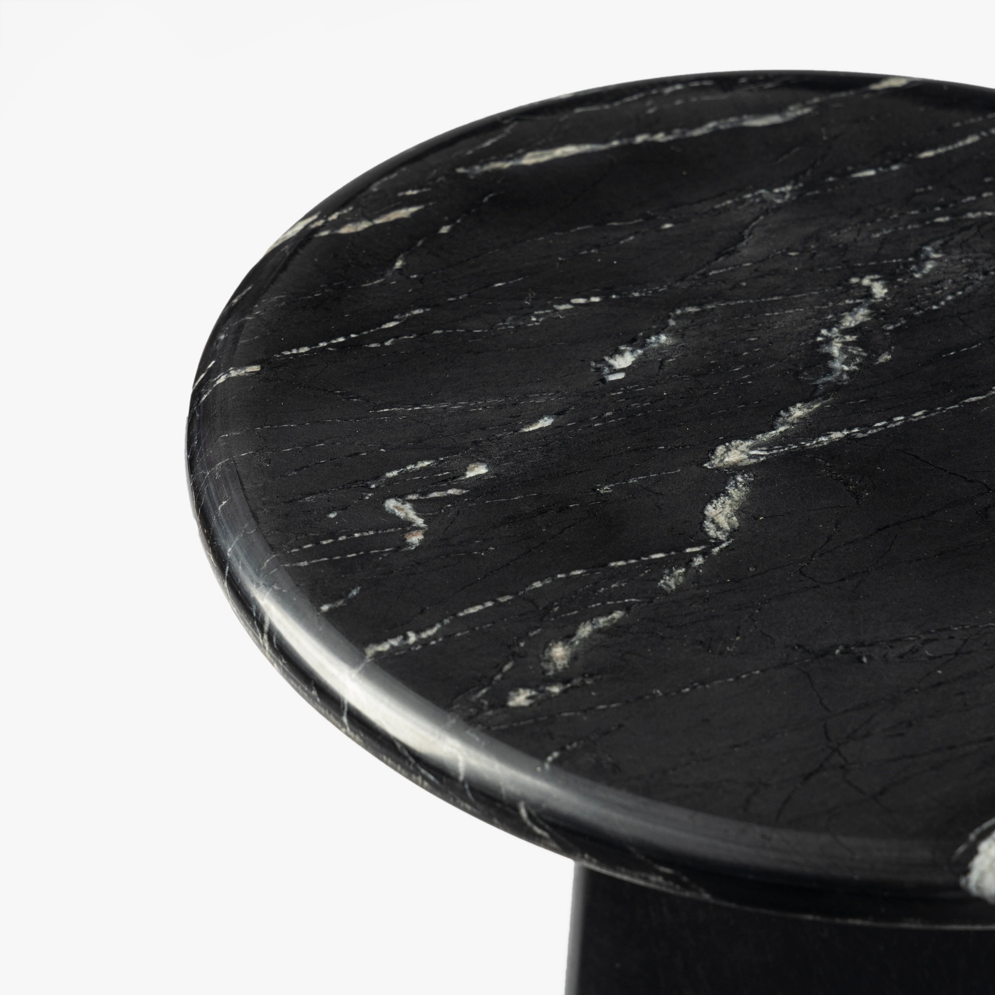 Round black marble table top on a white background