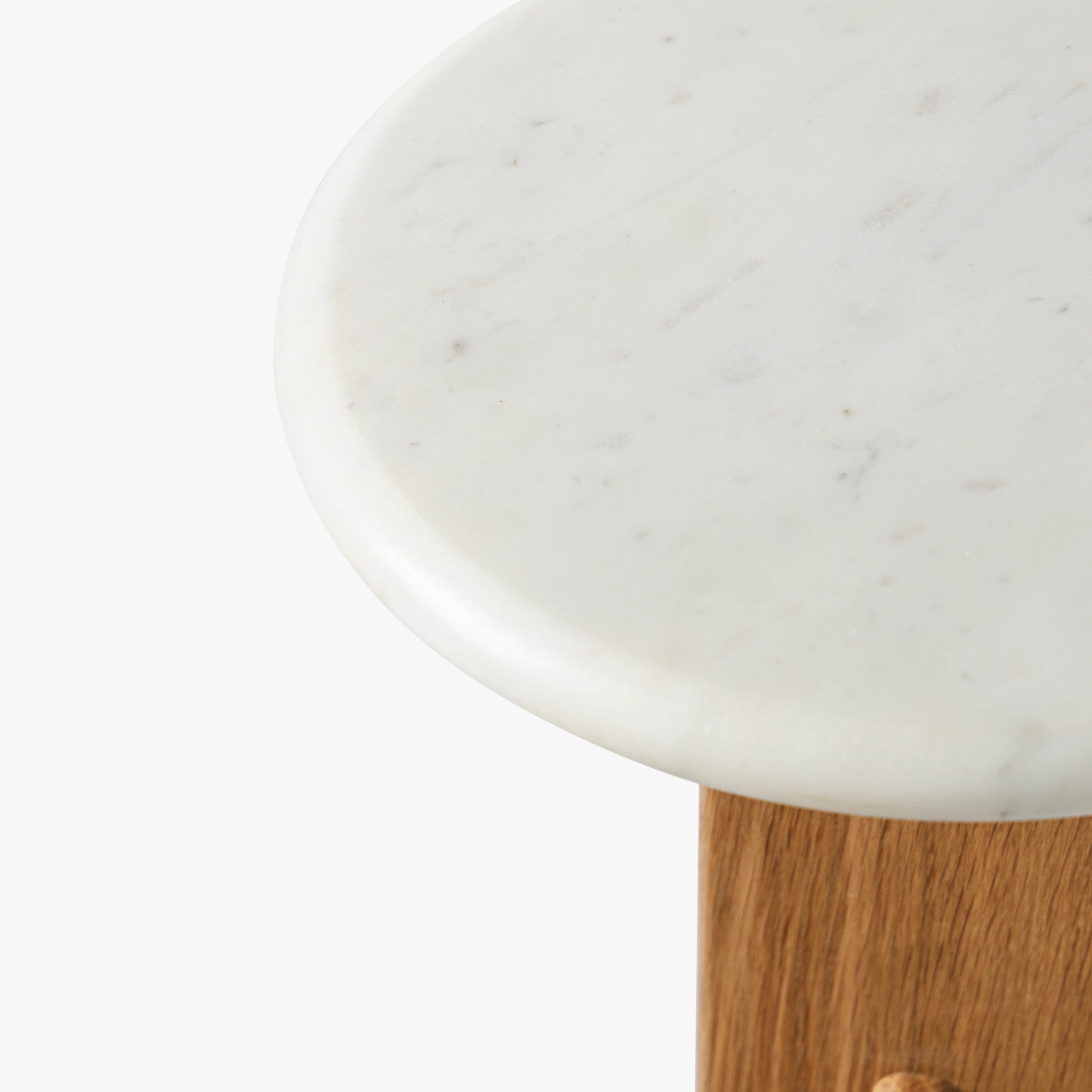 Close-up of a white marble surface with a wooden base