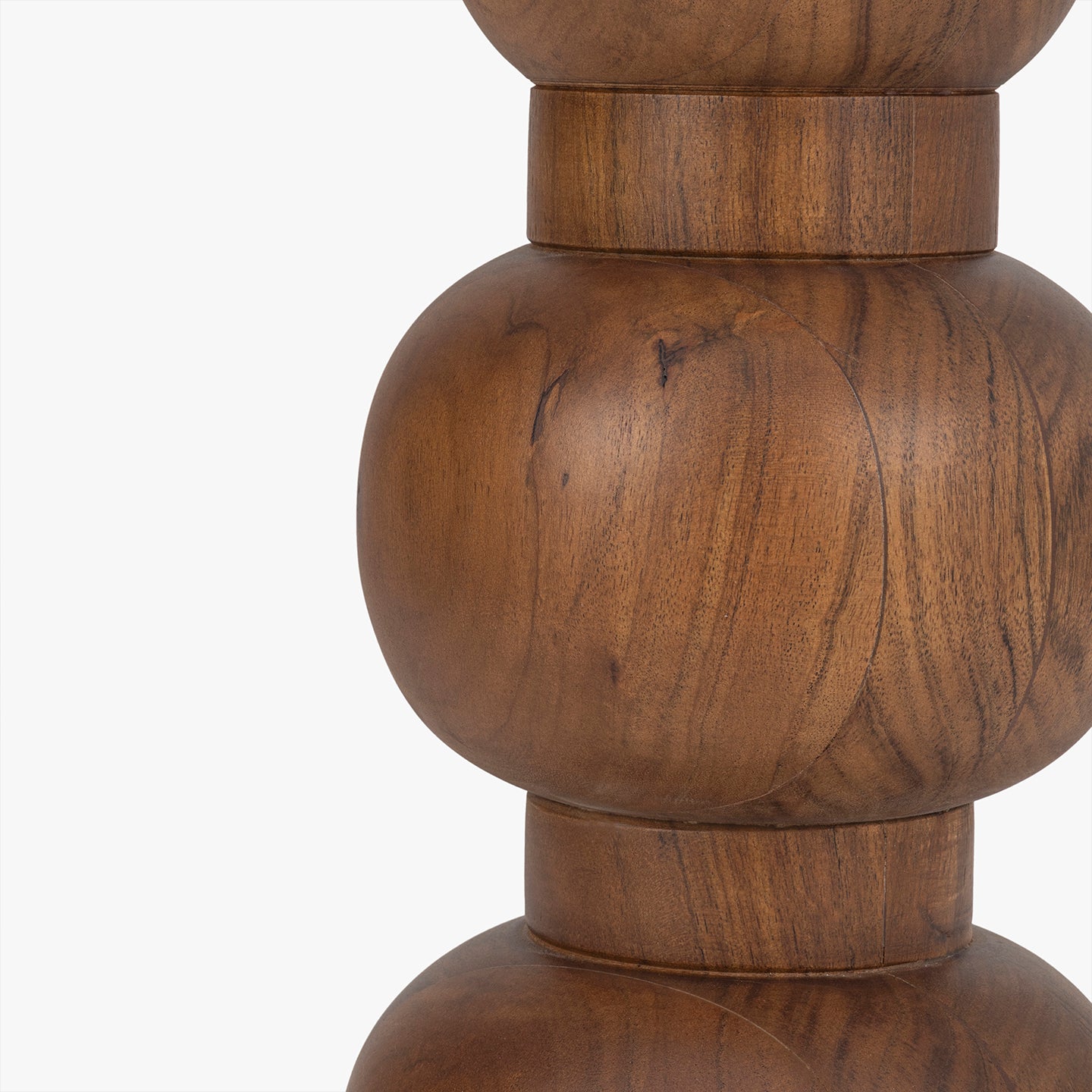 Close-up of a wooden side table base with round detailing on a white background
