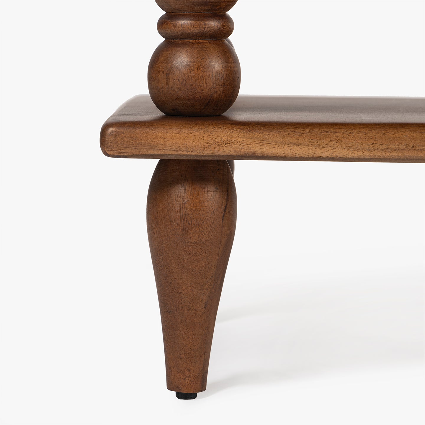 Close-up of a wooden table leg on a white background
