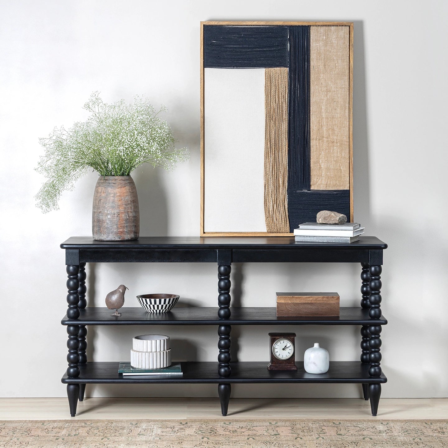 Black console table with decorative items against a white wall