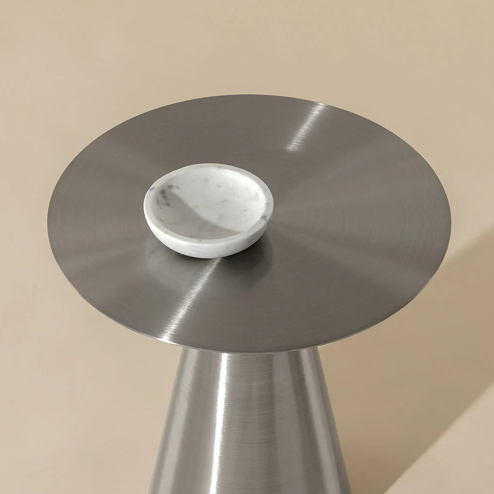 Small round table with marble top and metal base on a beige background