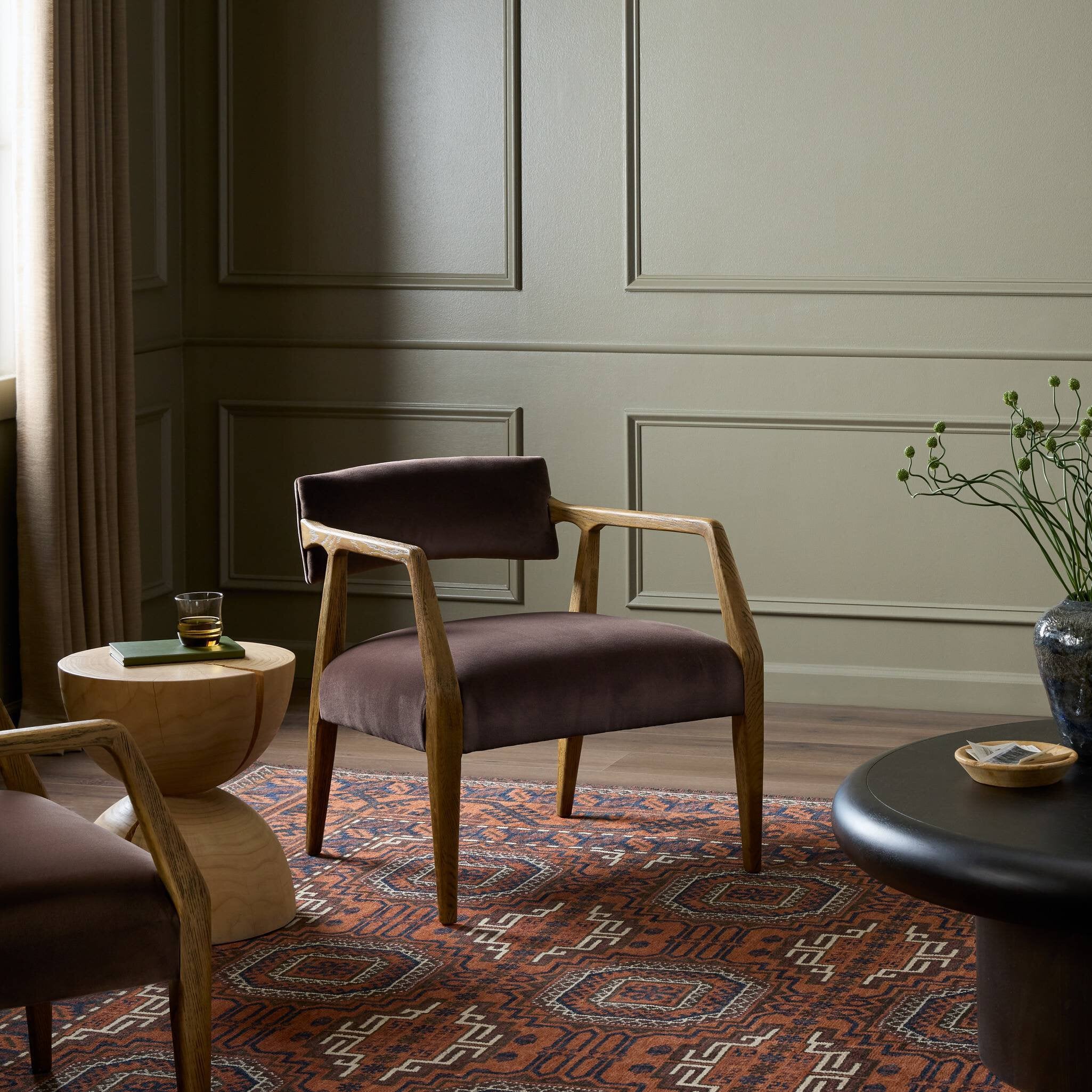 Brown armchair in a stylish room with a patterned rug and decorative elements.