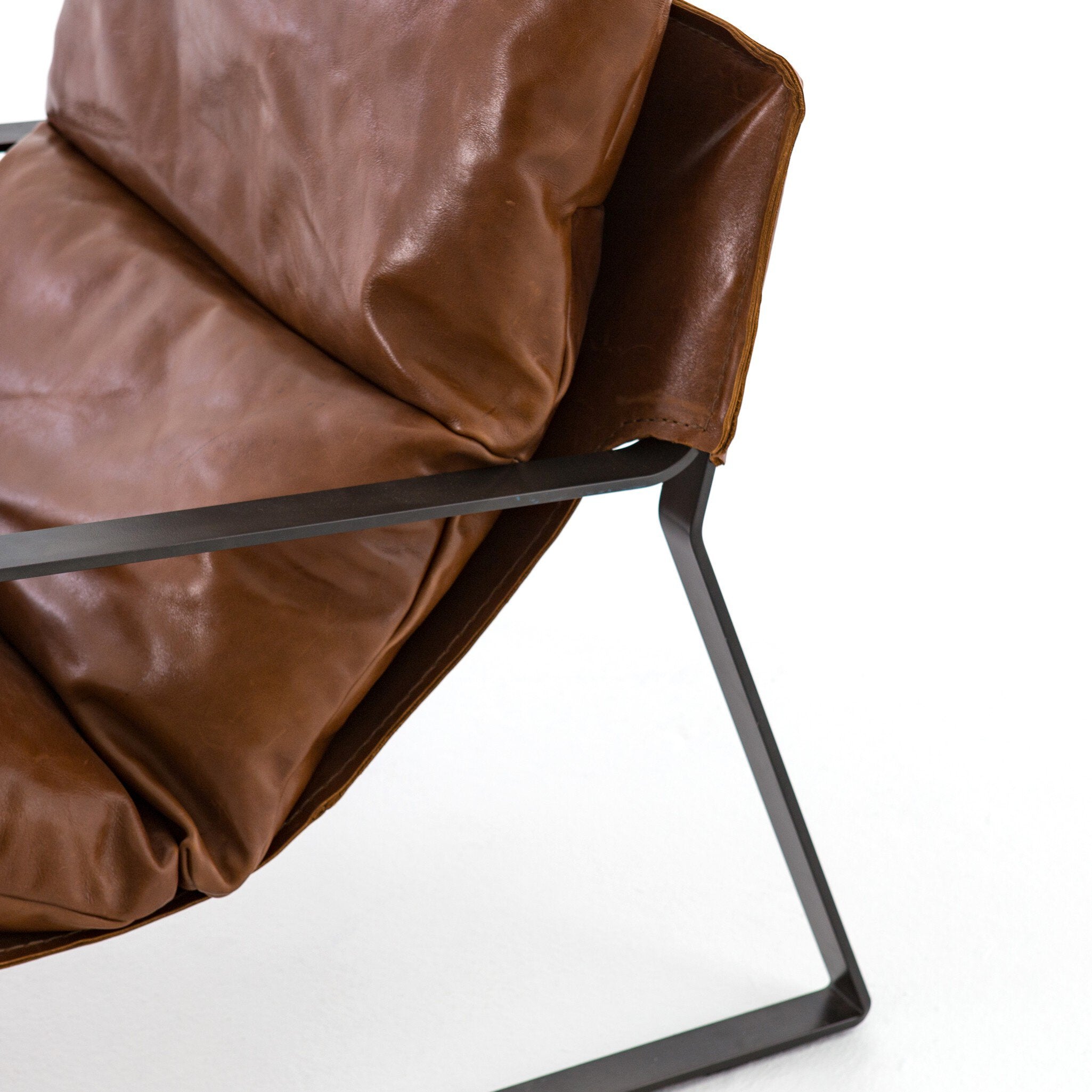 Brown leather chair with black metal frame on a white background