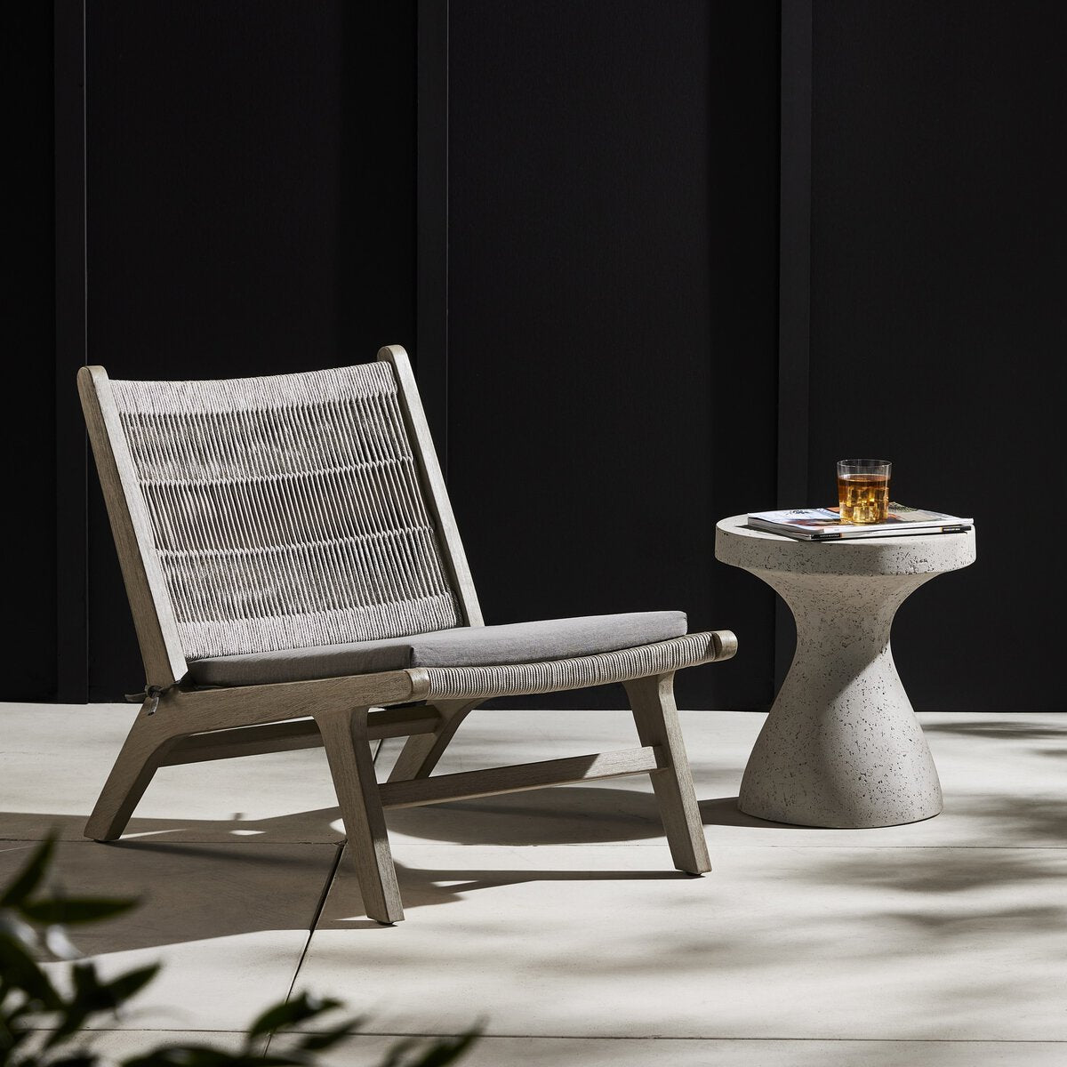 Modern lounge chair with a side table on a dark background