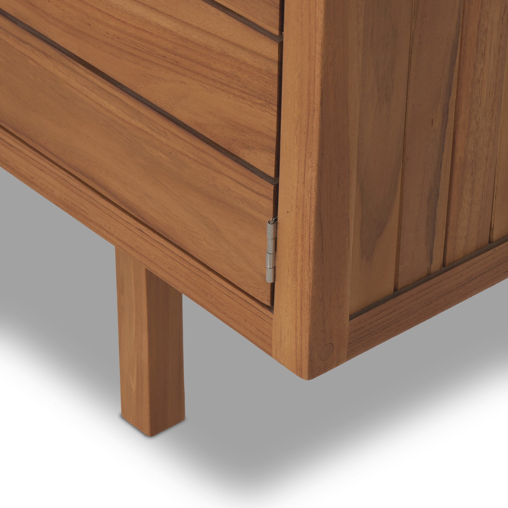 Close-up of a wooden cabinet with a focus on the corner and leg.