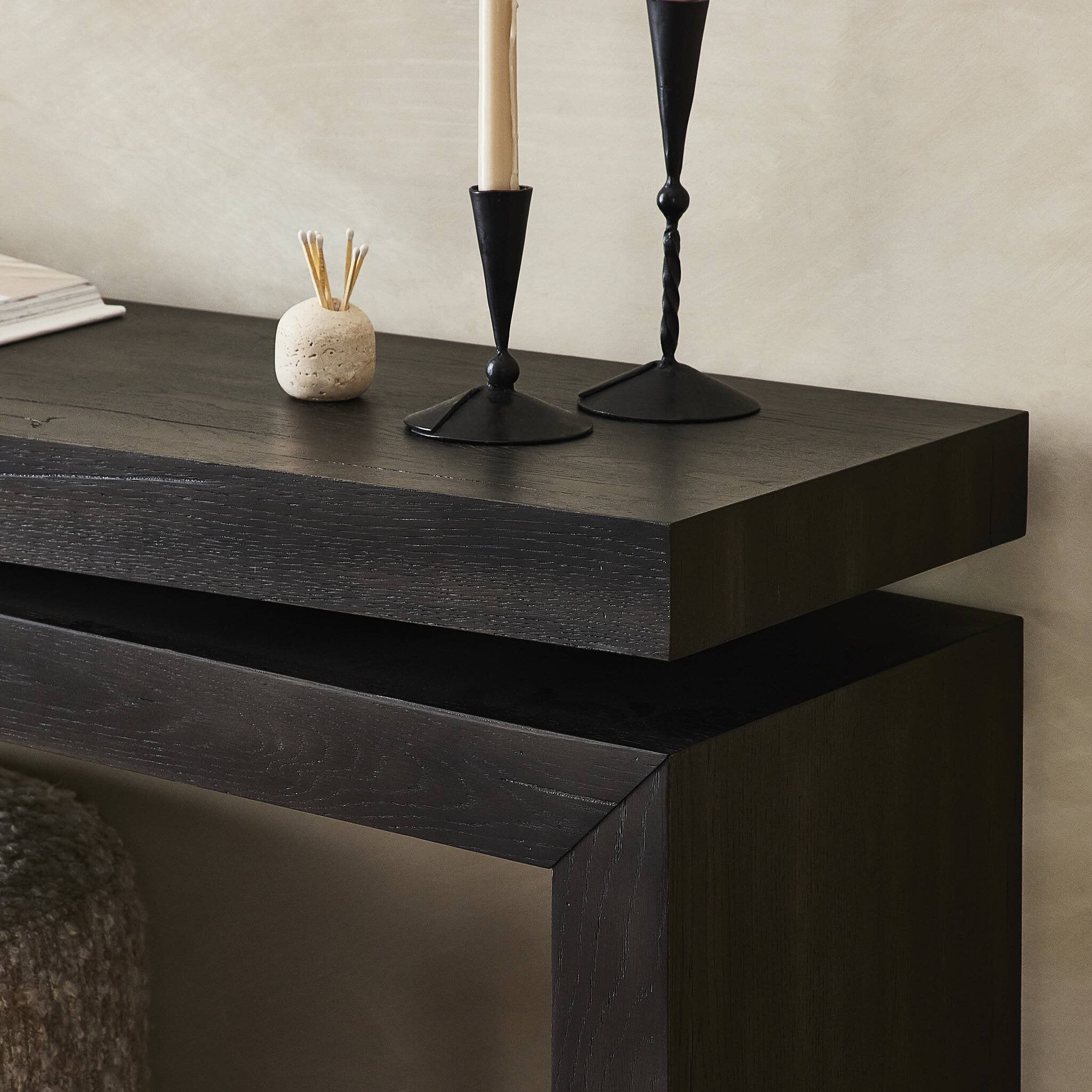 Dark wooden console table with decorative items against a neutral wall