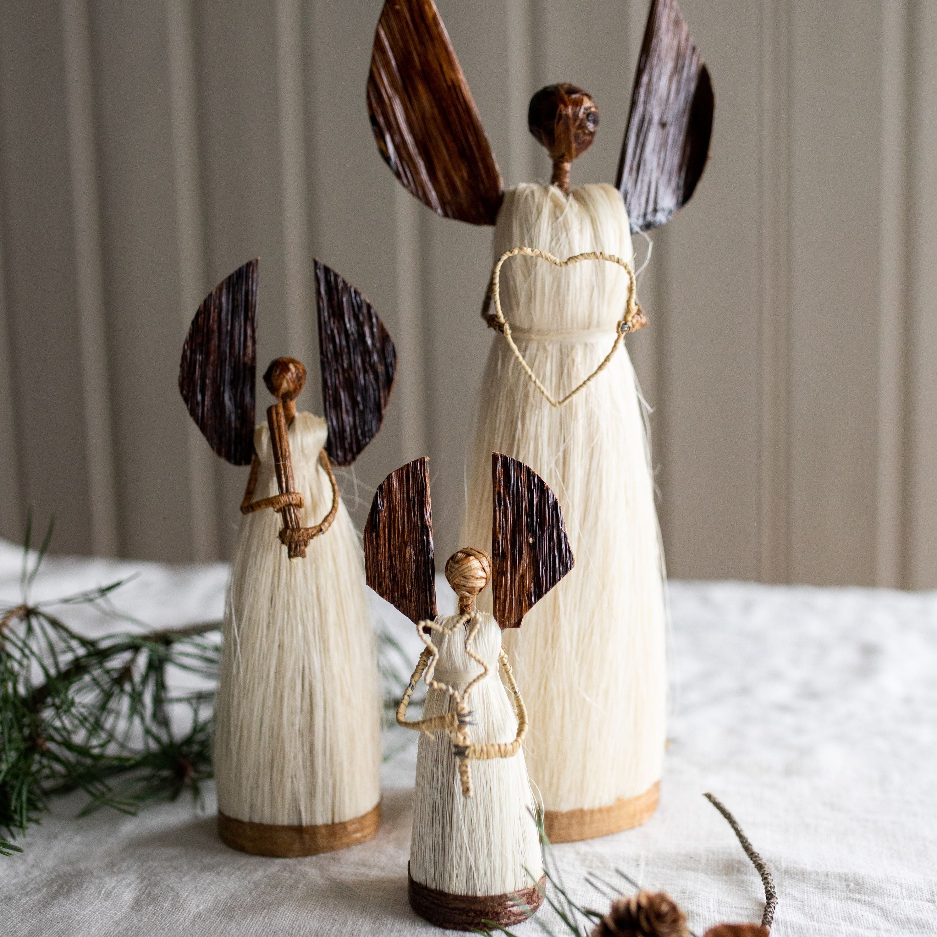 Wooden angel figurines on a textured surface with a neutral background