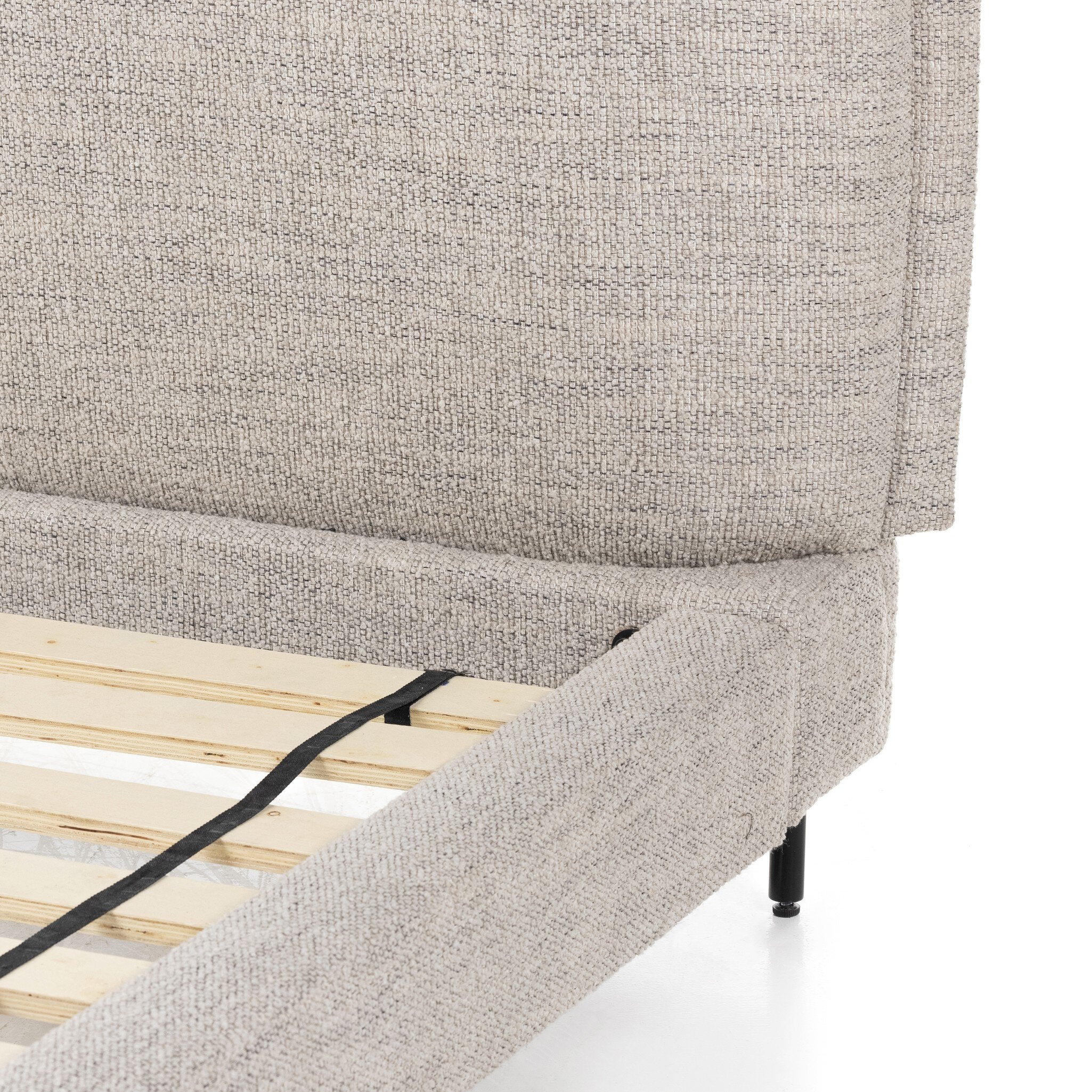 Gray upholstered bed frame with wooden slats on a white background
