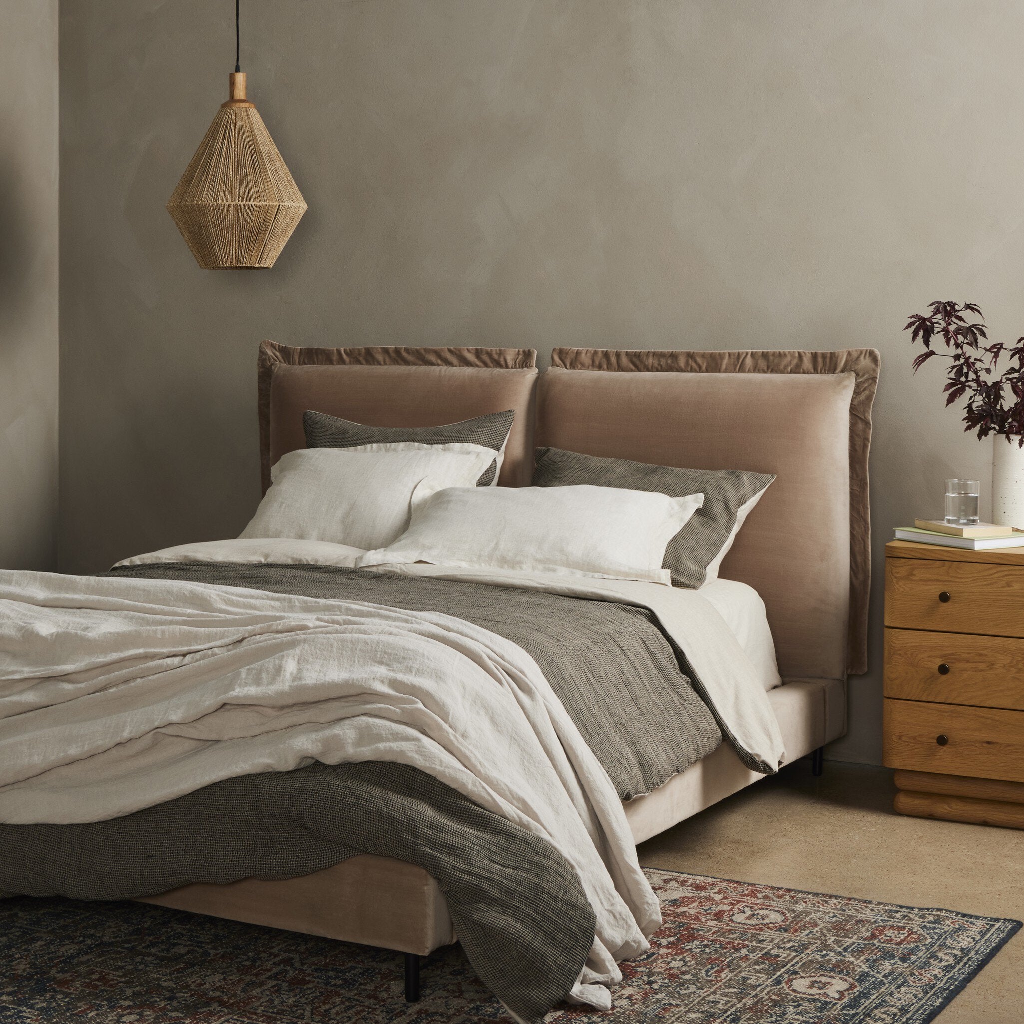 Upholstered velvet bedframe with beige bedding in a bedroom setting