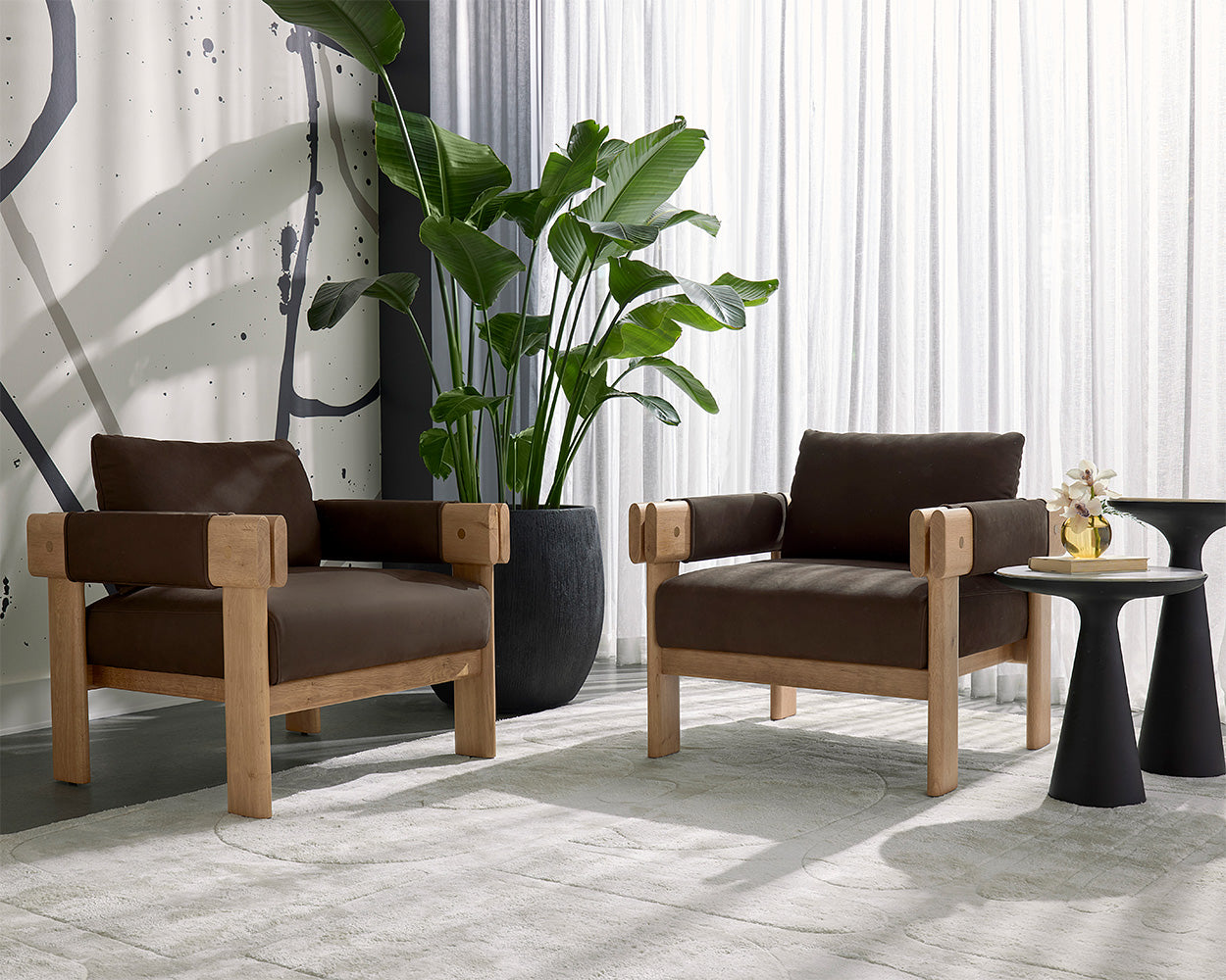 Two brown armchairs with wooden frames in a modern room setting.