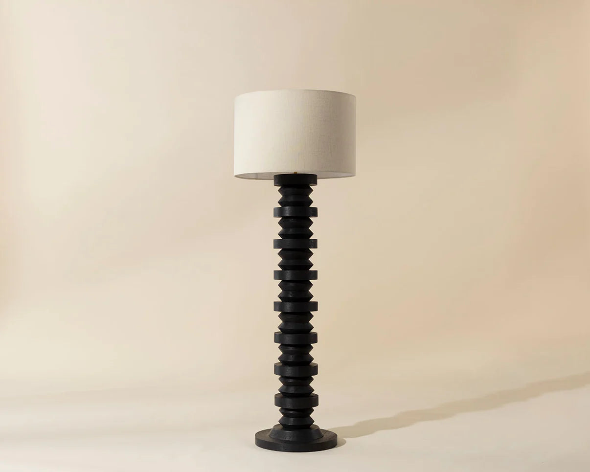 Decorative floor lamp with a black spiral base and white shade on a beige background