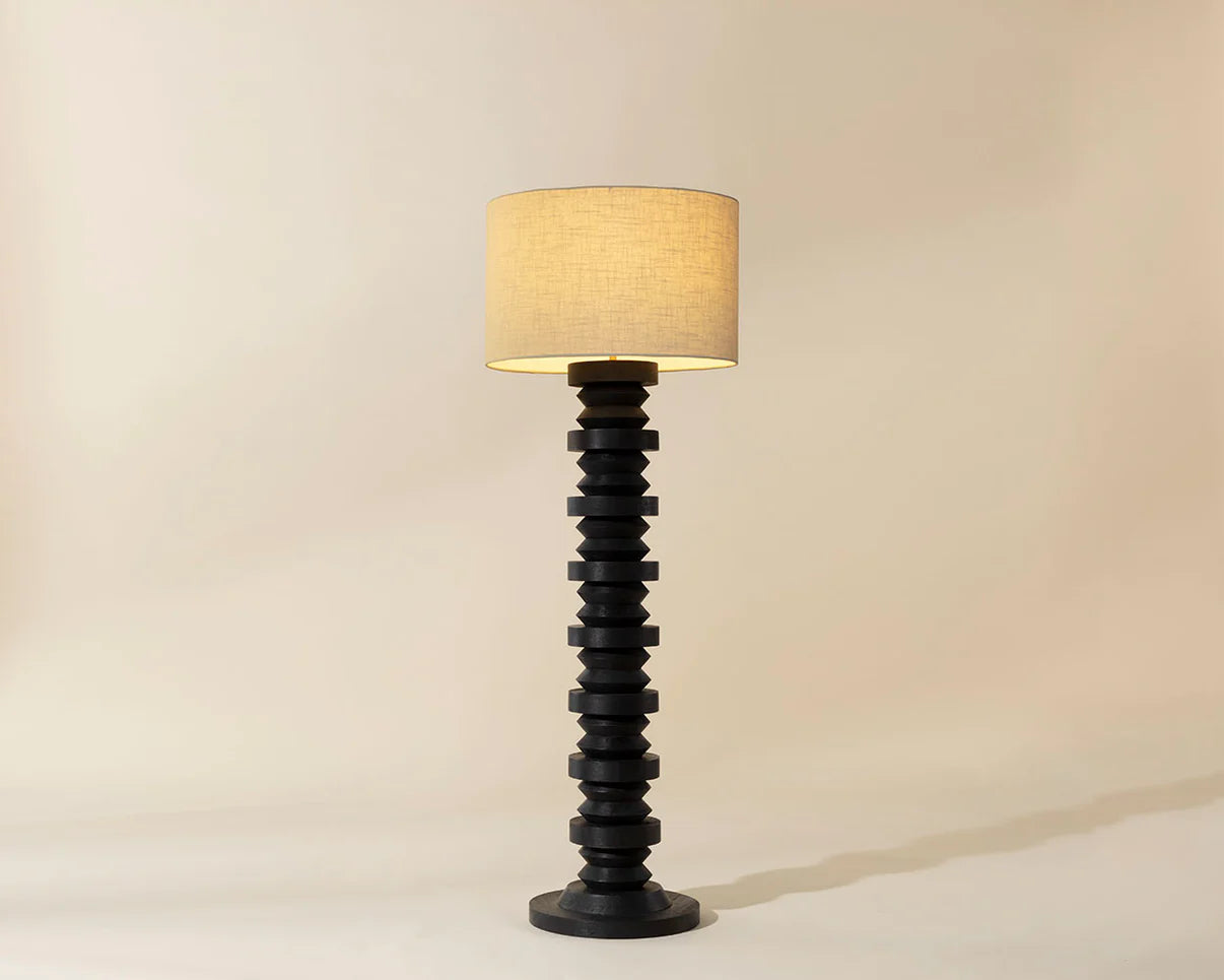 Decorative floor lamp with a black spiral base and beige lampshade on a neutral background
