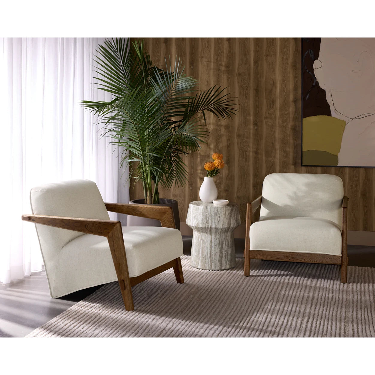 Two white armchairs with wooden frames in a living room setting.