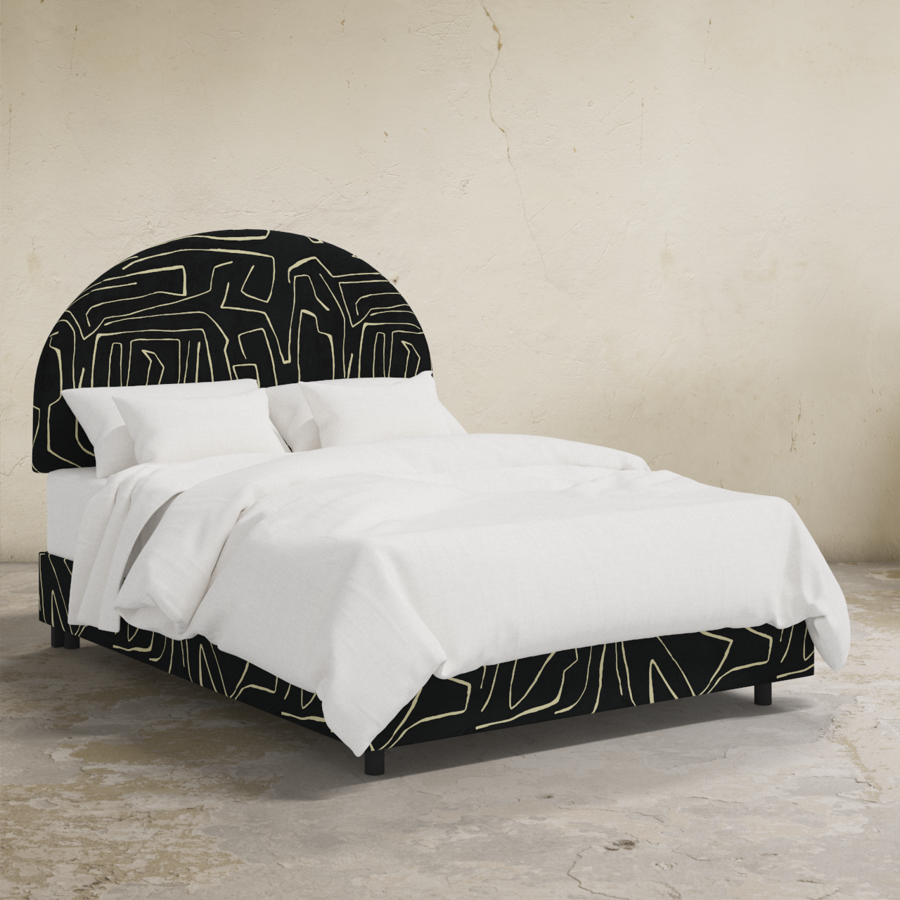 Bed with black and white geometric headboard and bedding on a neutral background