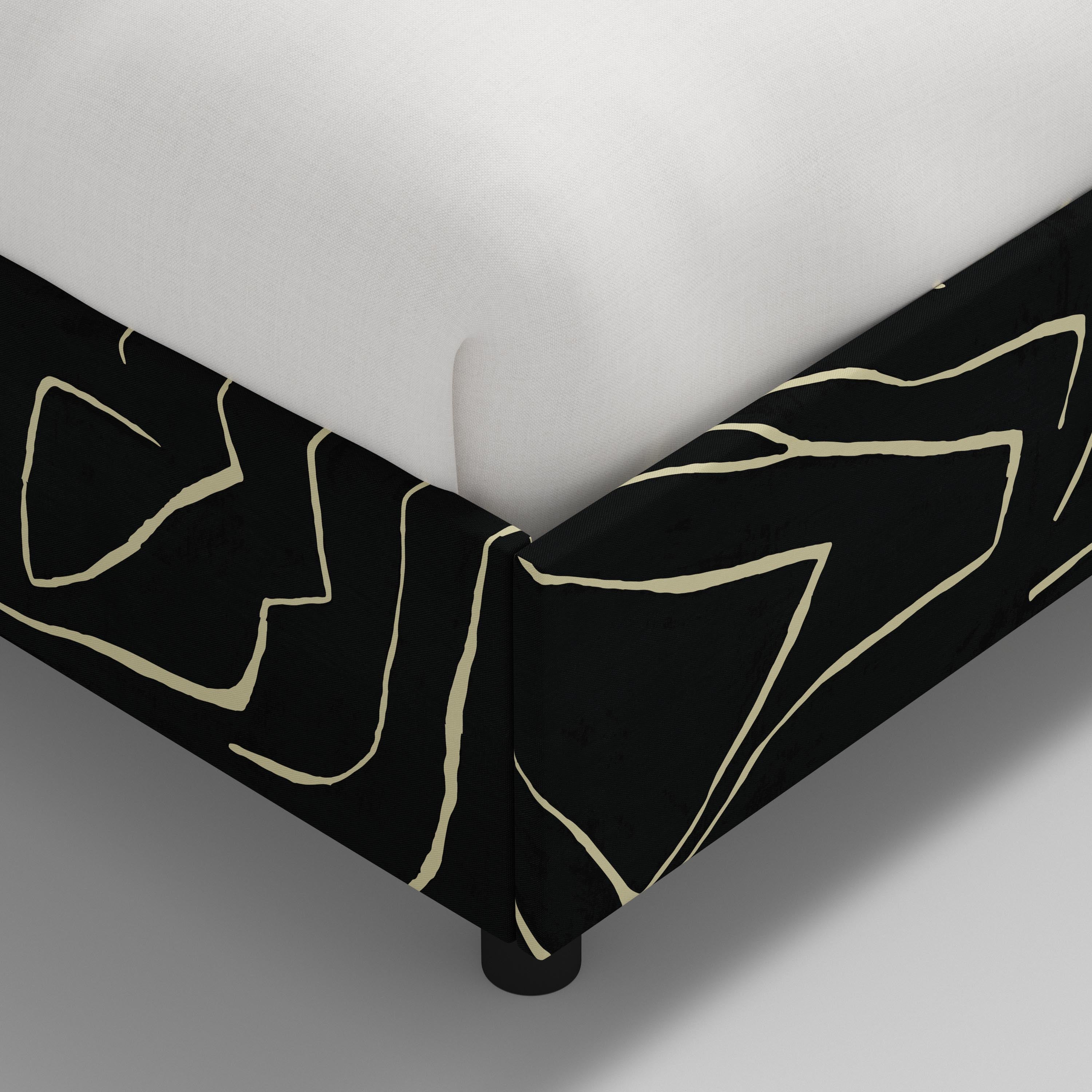 Bed with black geometric headboard and footboard on a white background