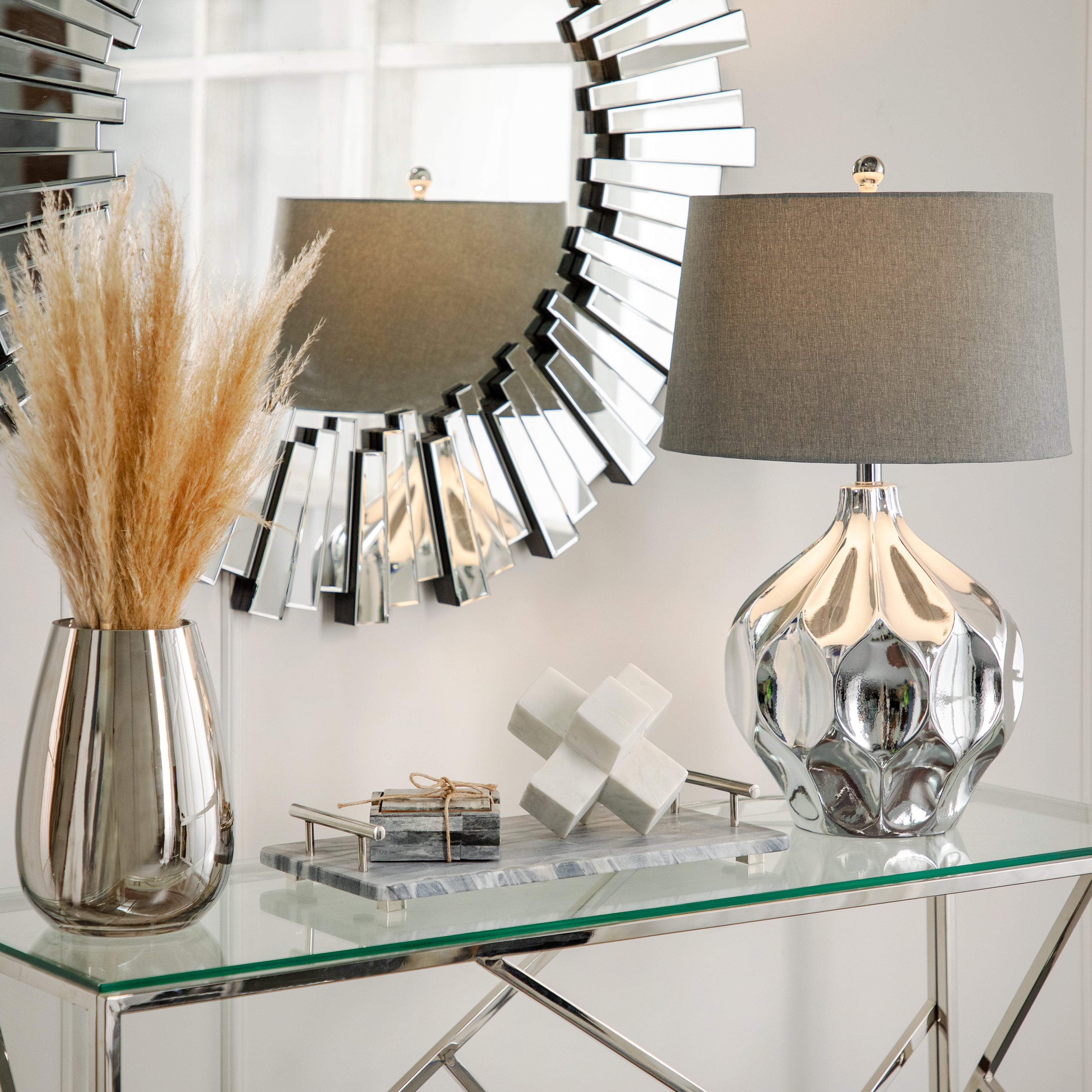 Decorative table with lamp, mirror, and vase in a stylish interior setting