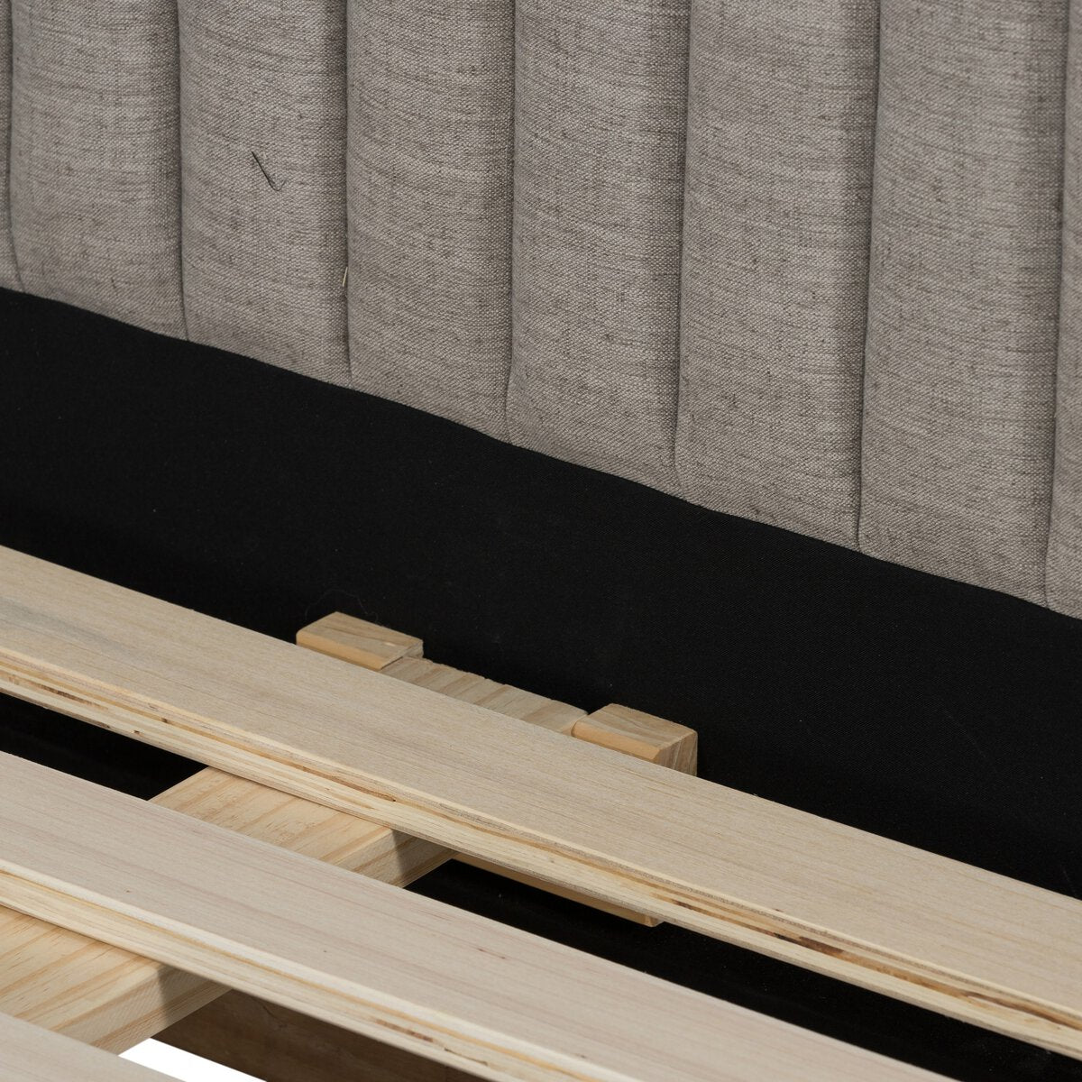 Wooden bed frame with a gray upholstered headboard on a black background