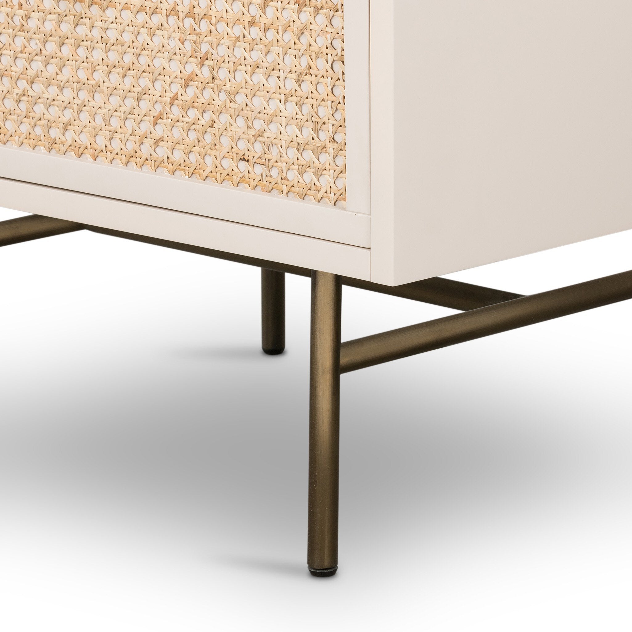 Close-up of a furniture piece with woven design and bronze legs on a white background