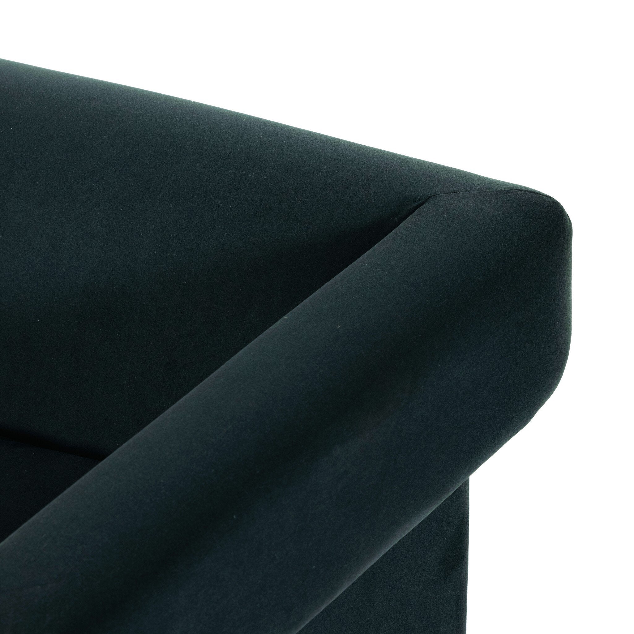 Dark green upholstered chair corner on a white background