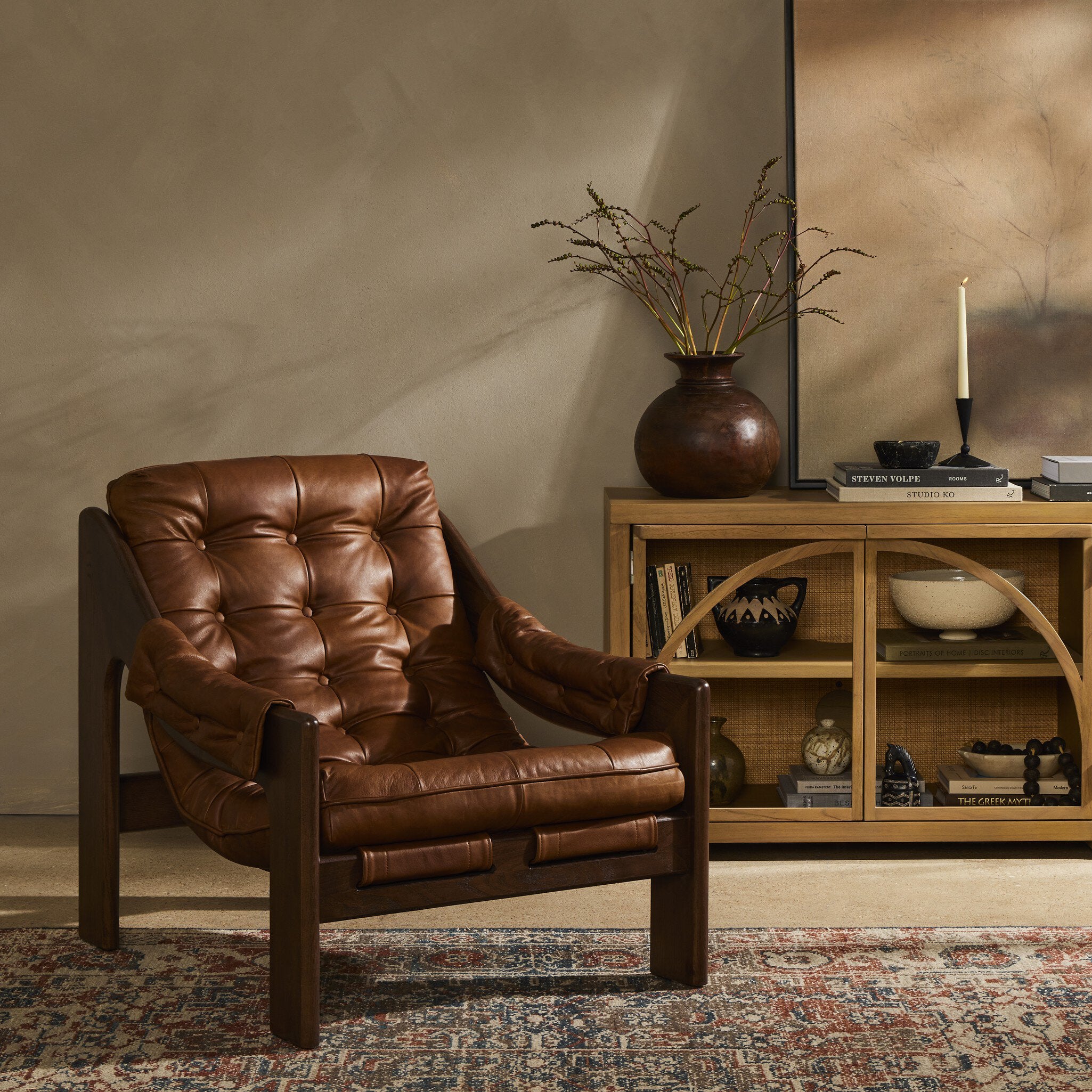 Brown leather armchair in a room with a wooden shelf and decorative items.