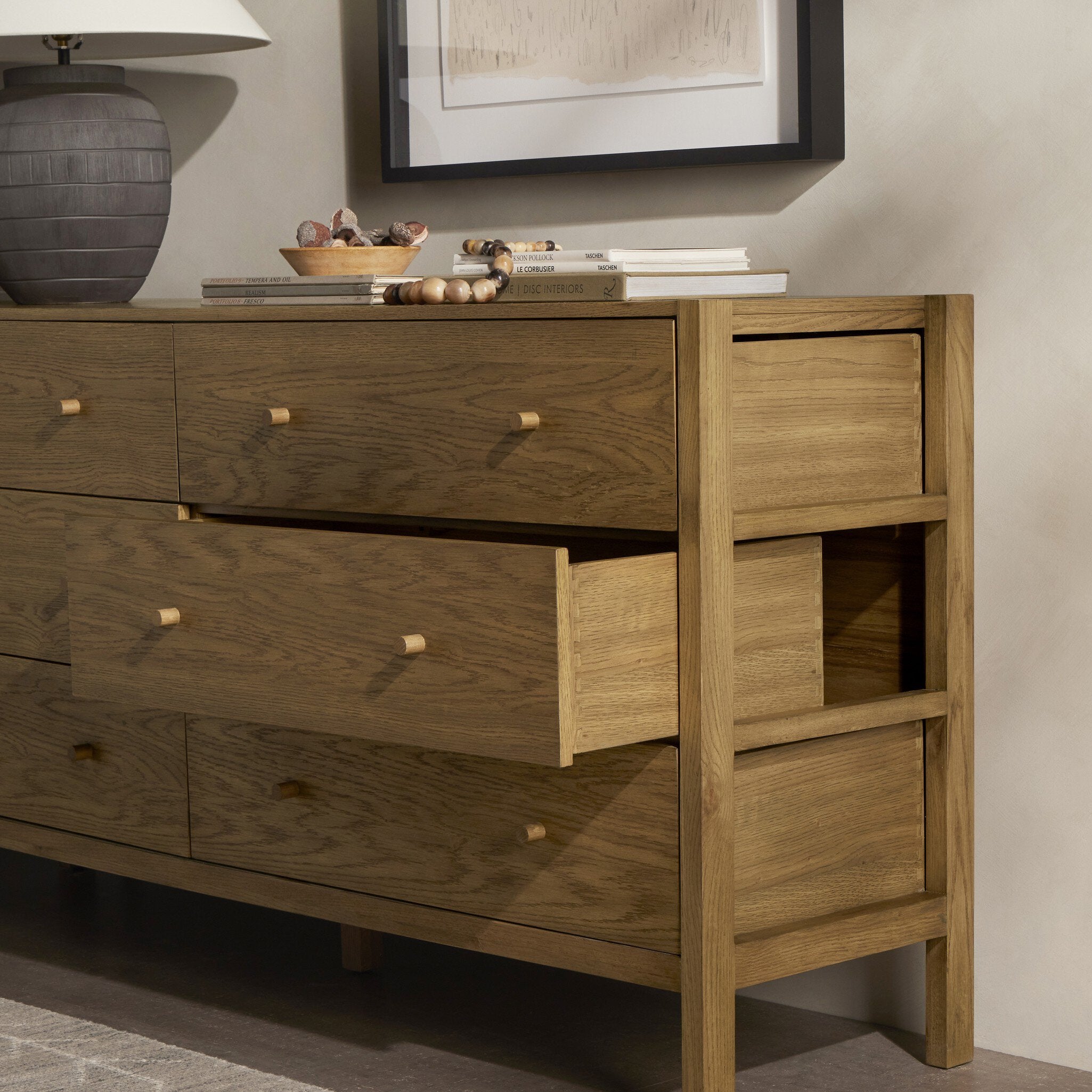 Wooden dresser with multiple drawers in a room setting.