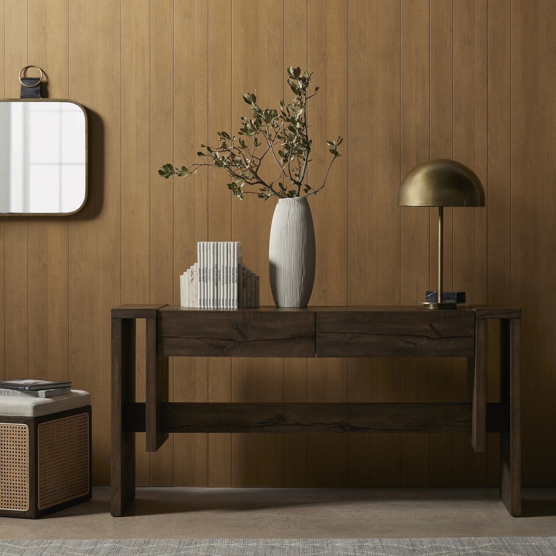 Wooden console table with travertine stone bookends against a wooden wall