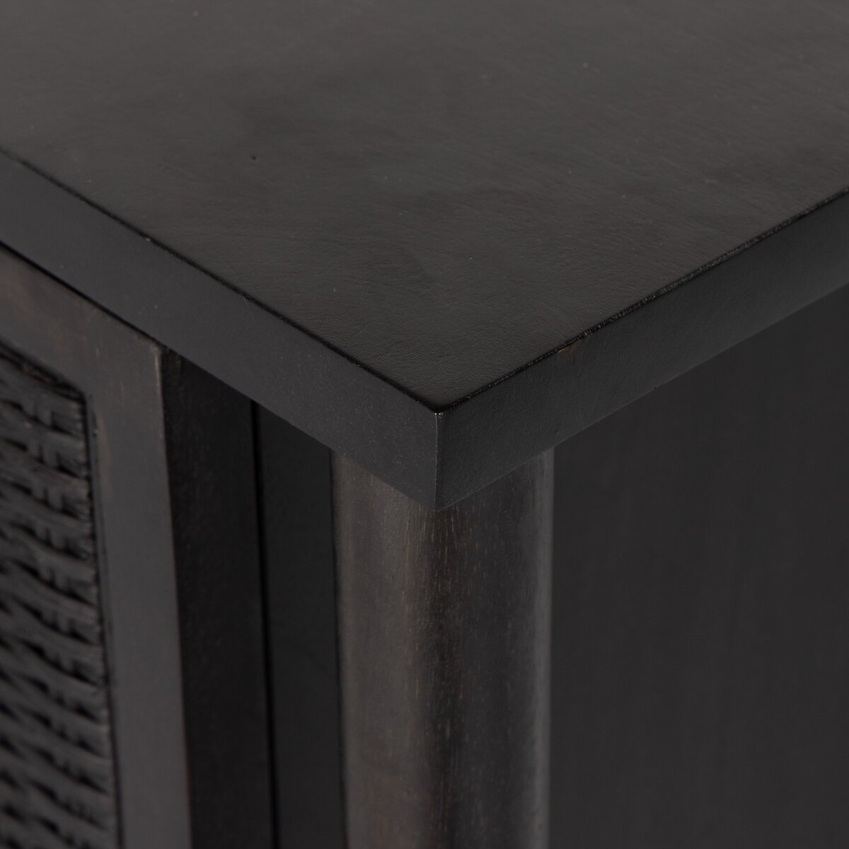 Close-up of a black cabinet corner with a textured finish
