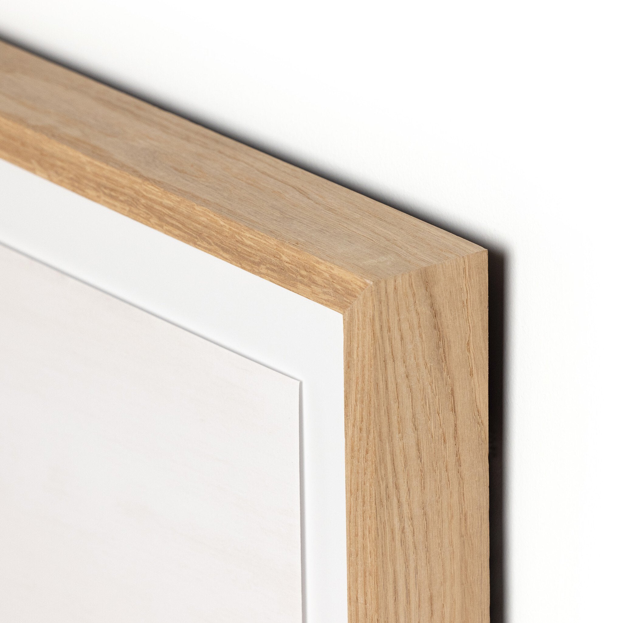 Close-up of a wooden picture frame corner on a white background
