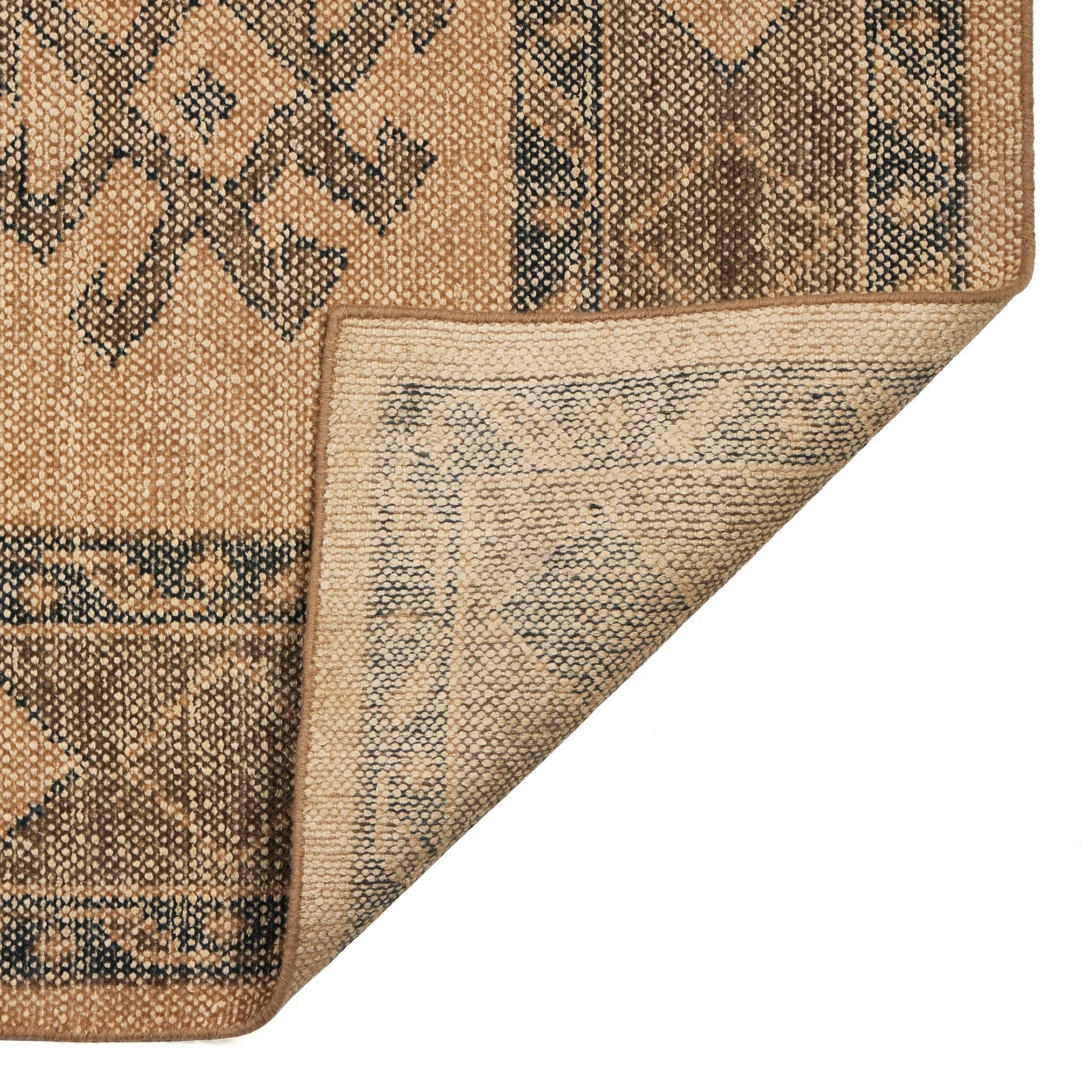 Close-up of a textured rug corner with geometric pattern