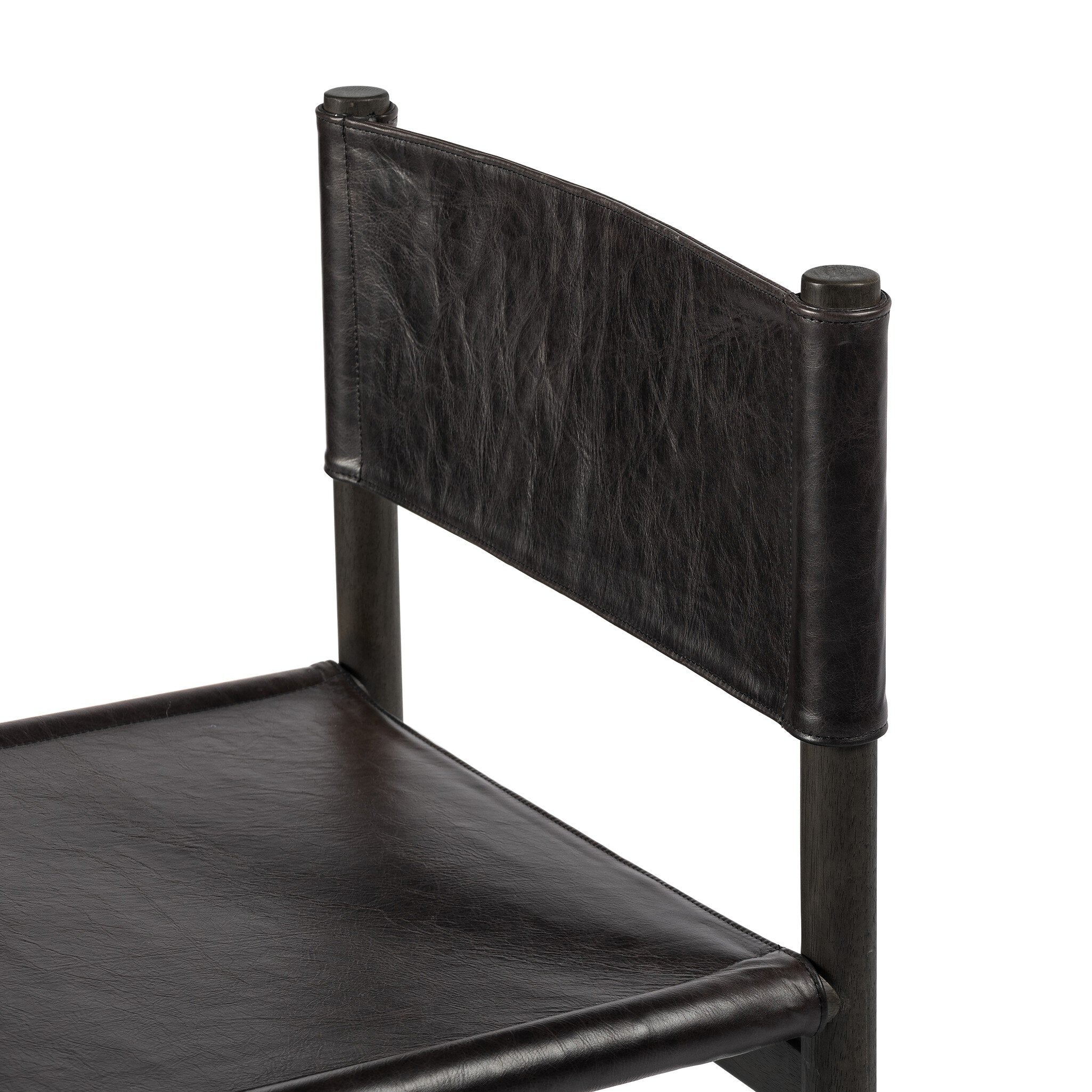 Detail of black leather and wooden dining chair on a white background