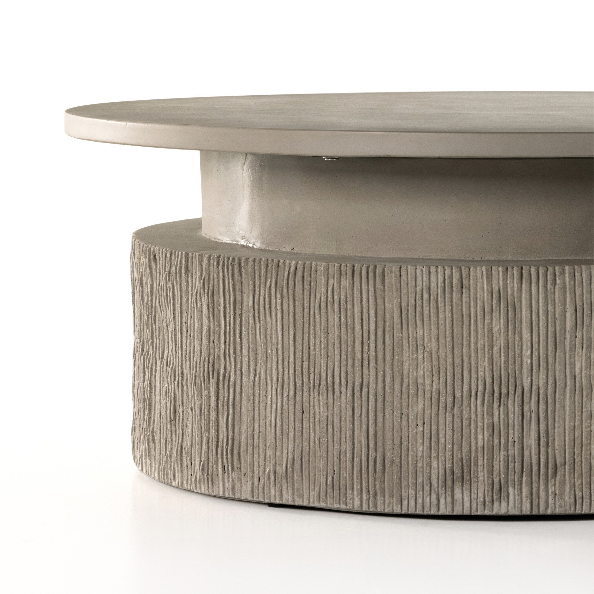 Round concrete coffee table with textured base on a white background