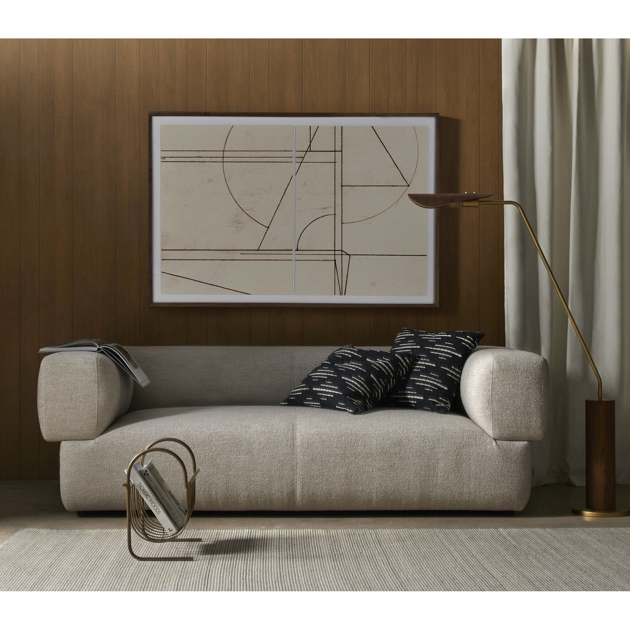 Modern living room with a beige sofa, decorative pillows, and a framed abstract art piece on the wall.