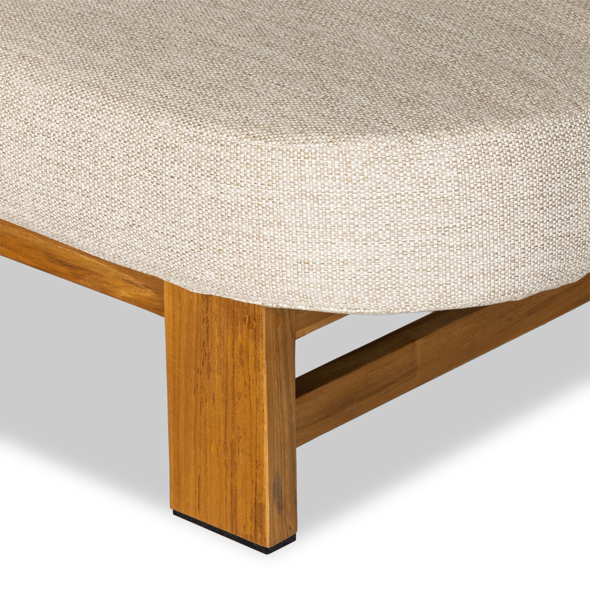 Close-up of a wooden bed frame with a textured mattress cover on a light gray background