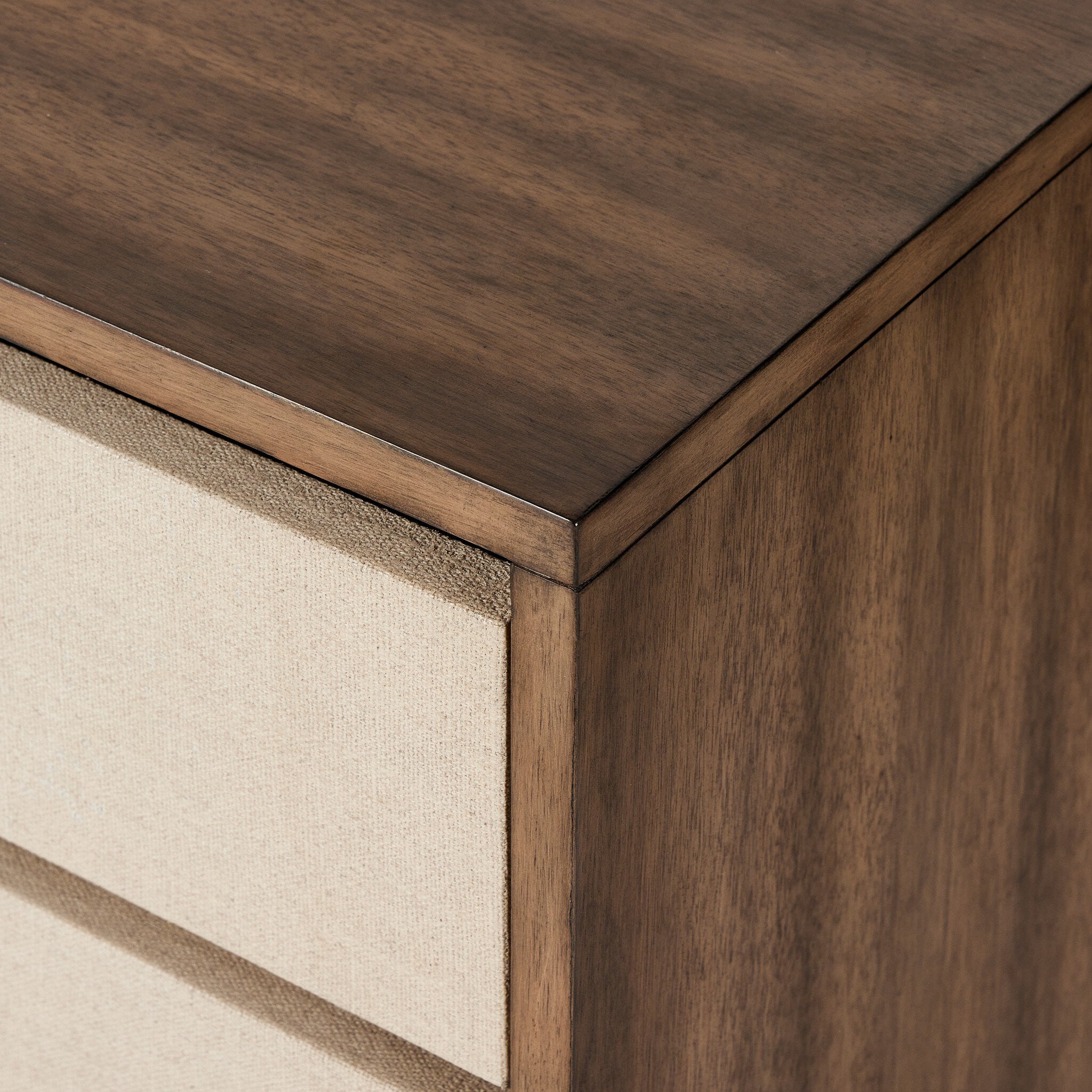 Close-up of a wooden nightstand with a textured drawer surface