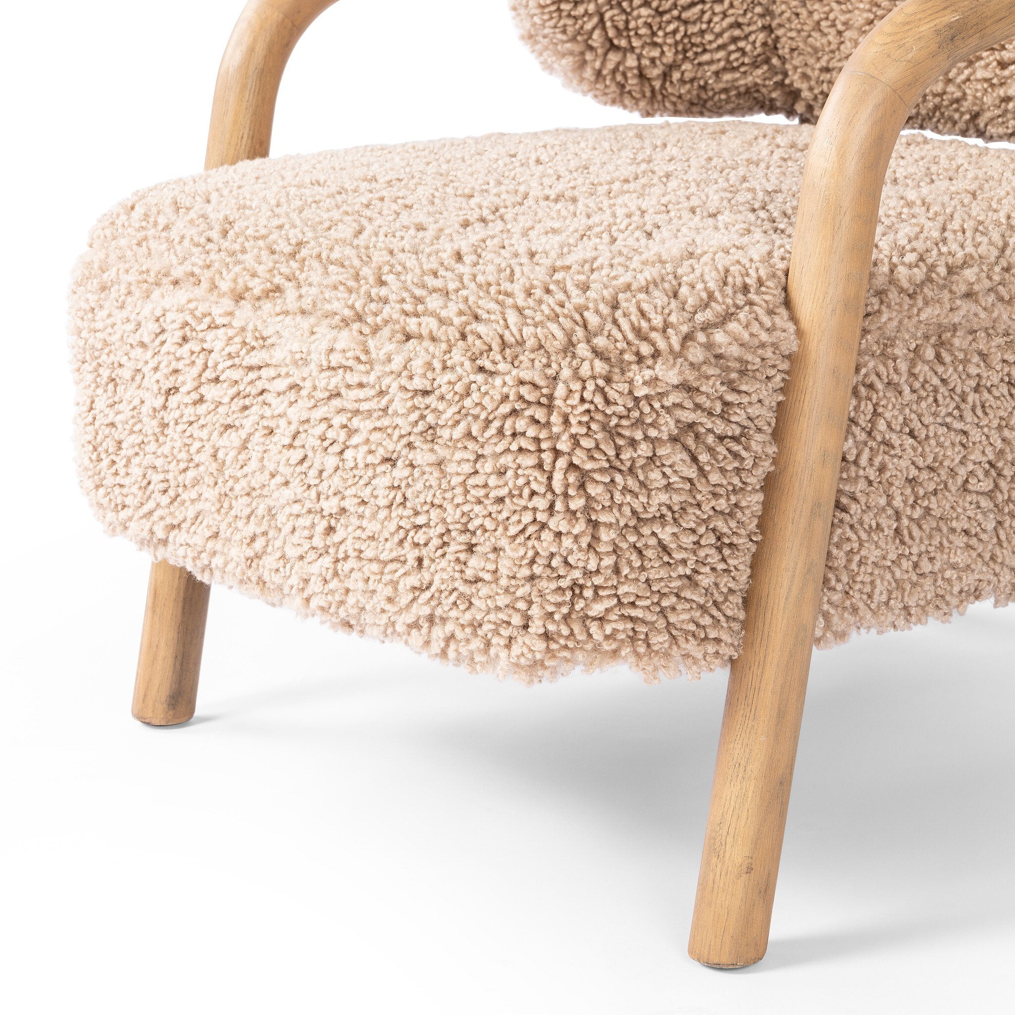Chair with beige sherpa fabric and wooden legs on a white background