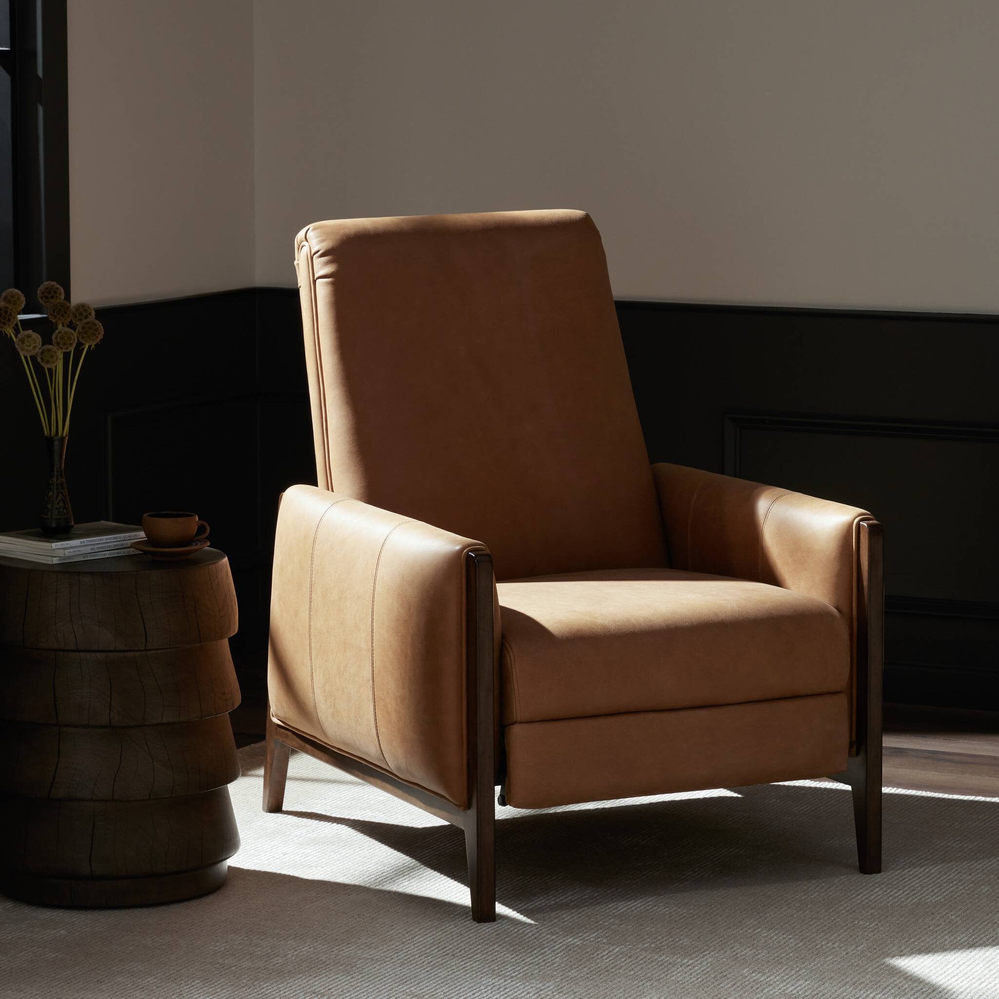 Brown leather armchair in a dimly lit room with a side table.