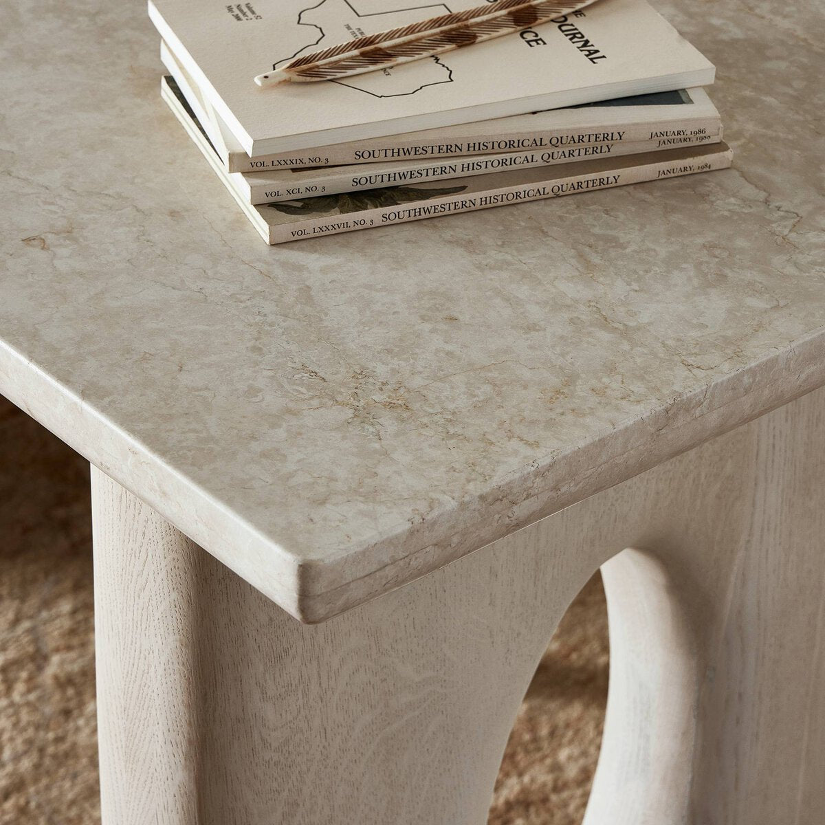 Beige marble table with books on a carpet background