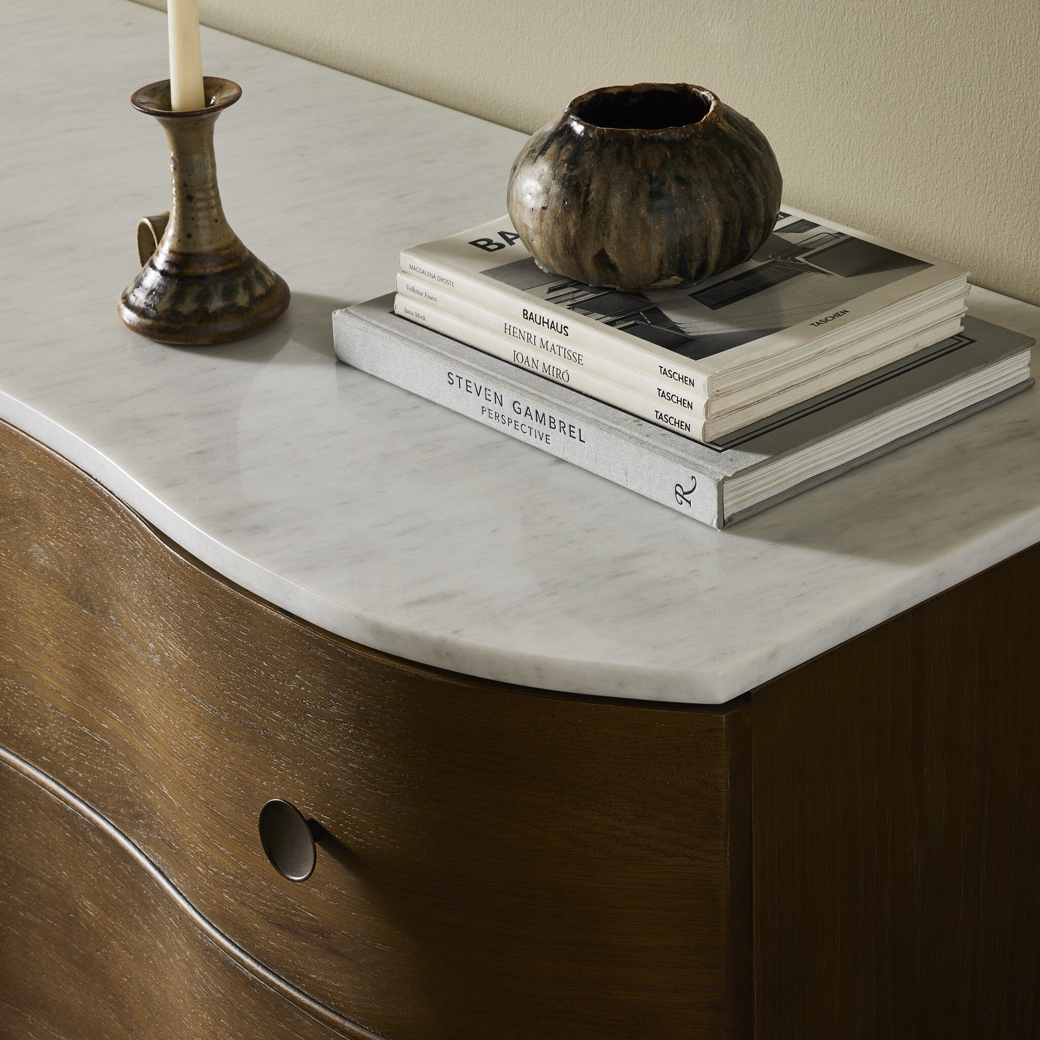 Stack of books on marble surface of chest with decorative items