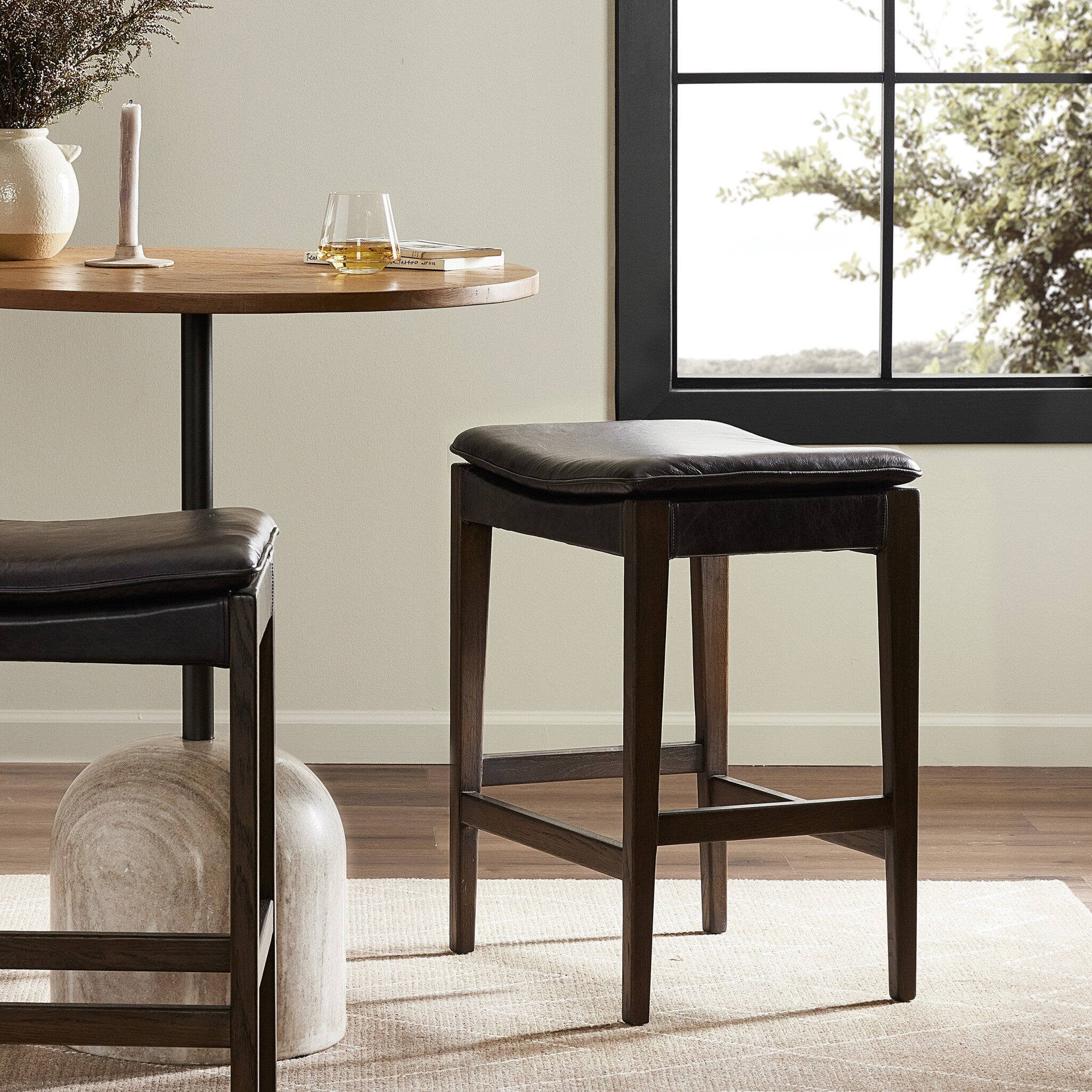 Bar stool with black leather seat and wooden frame