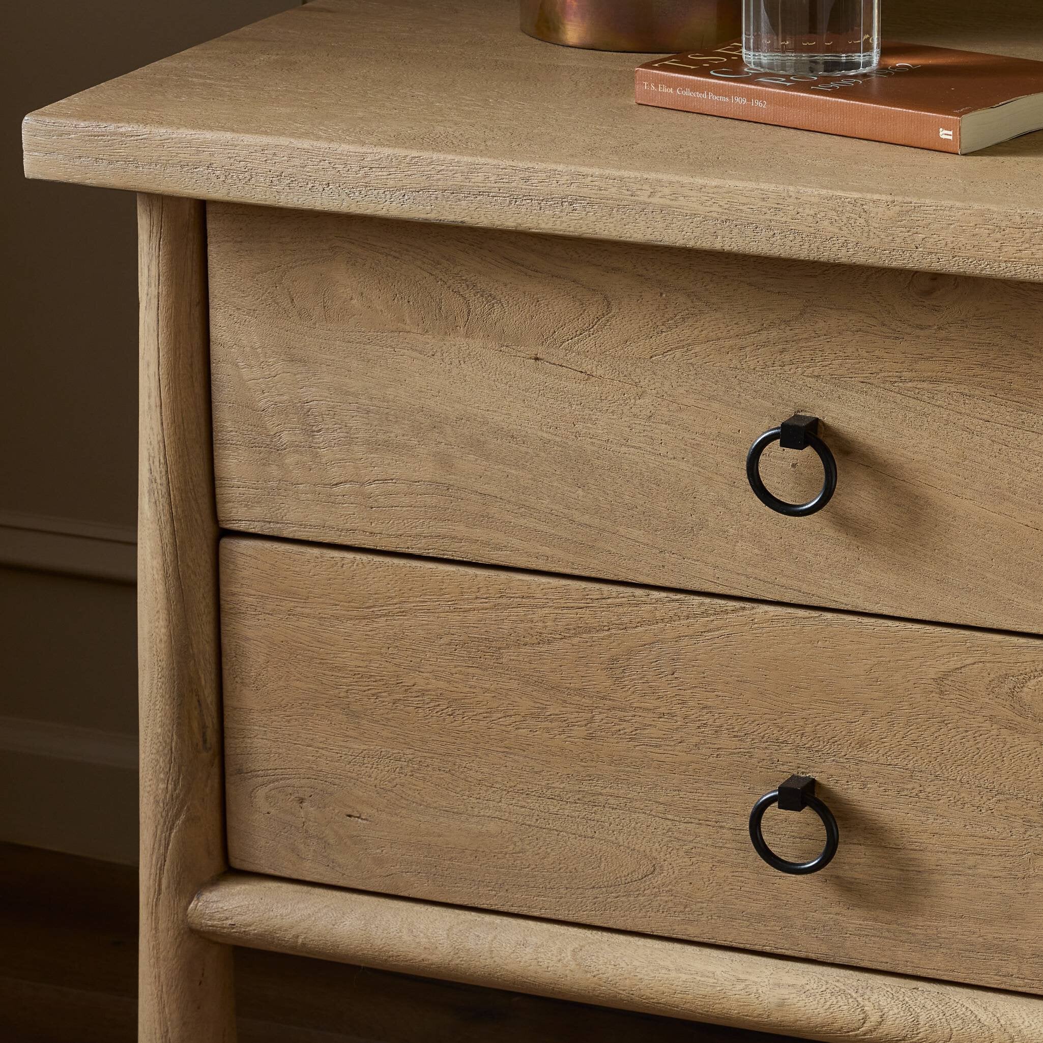 Wooden dresser with two drawers and black ring handles on a wooden drawer
