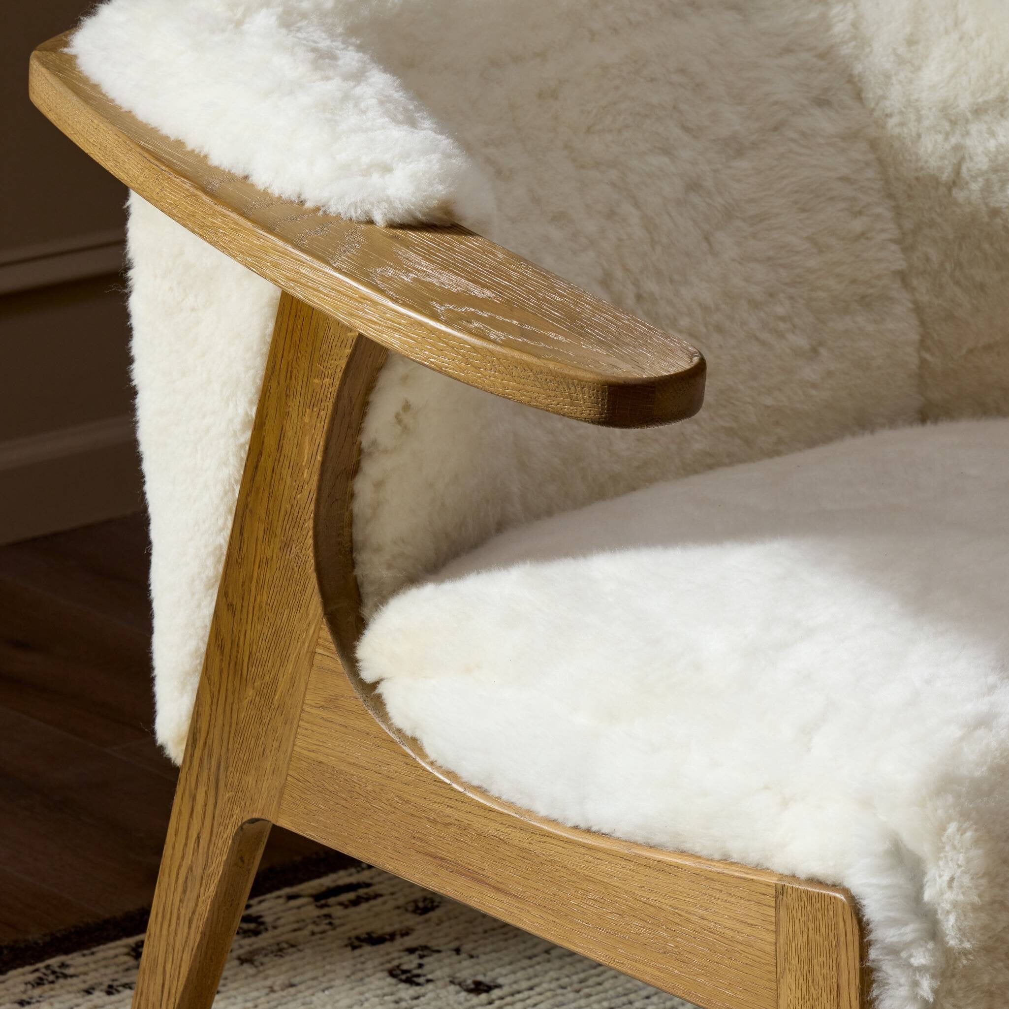 Wooden chair with white fur cushion on a wooden floor