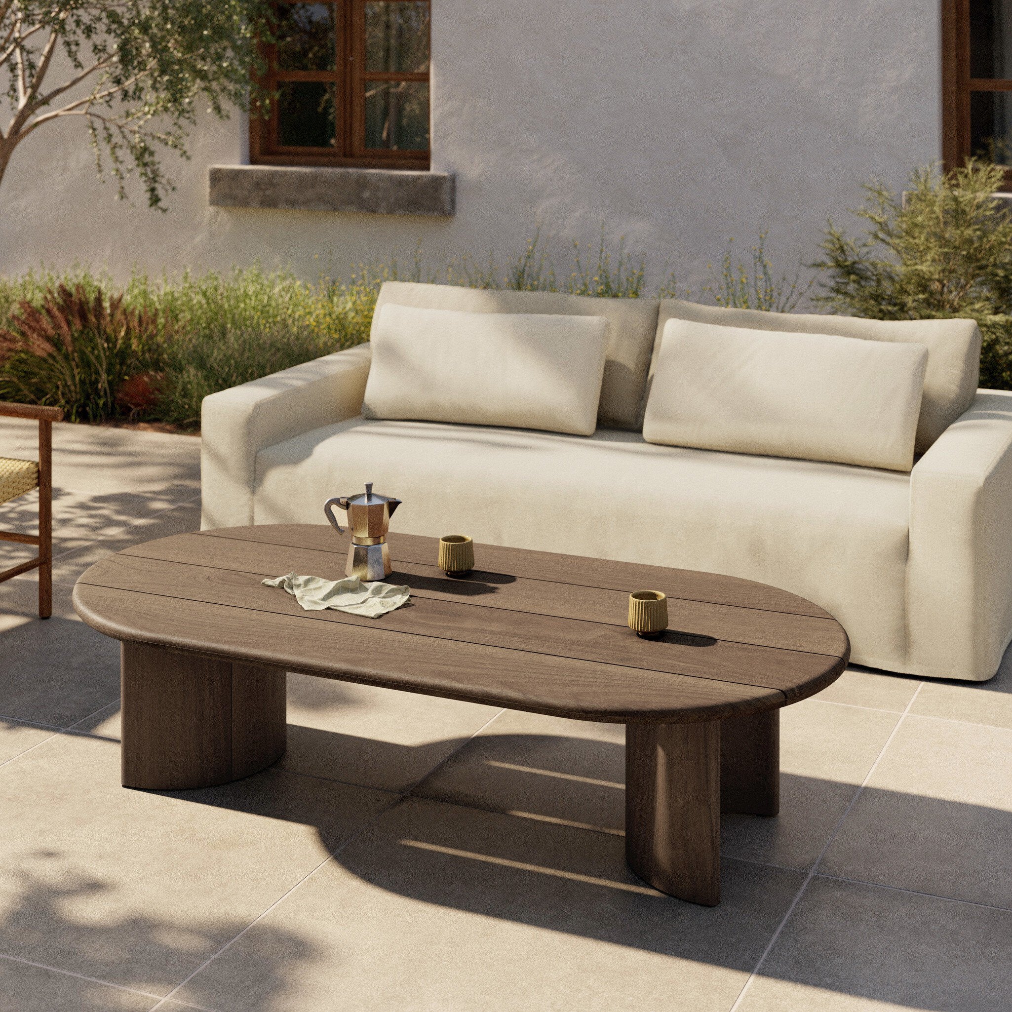 Beige outdoor sofa with a wooden coffee table in a garden setting
