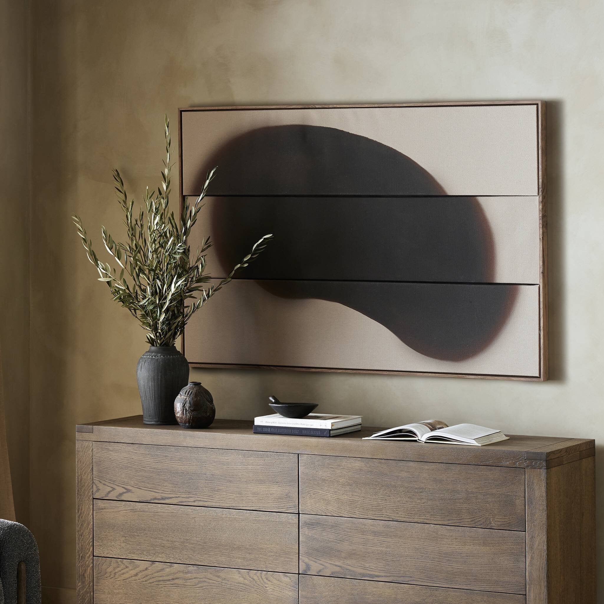 Wooden dresser with decorative items against a beige wall