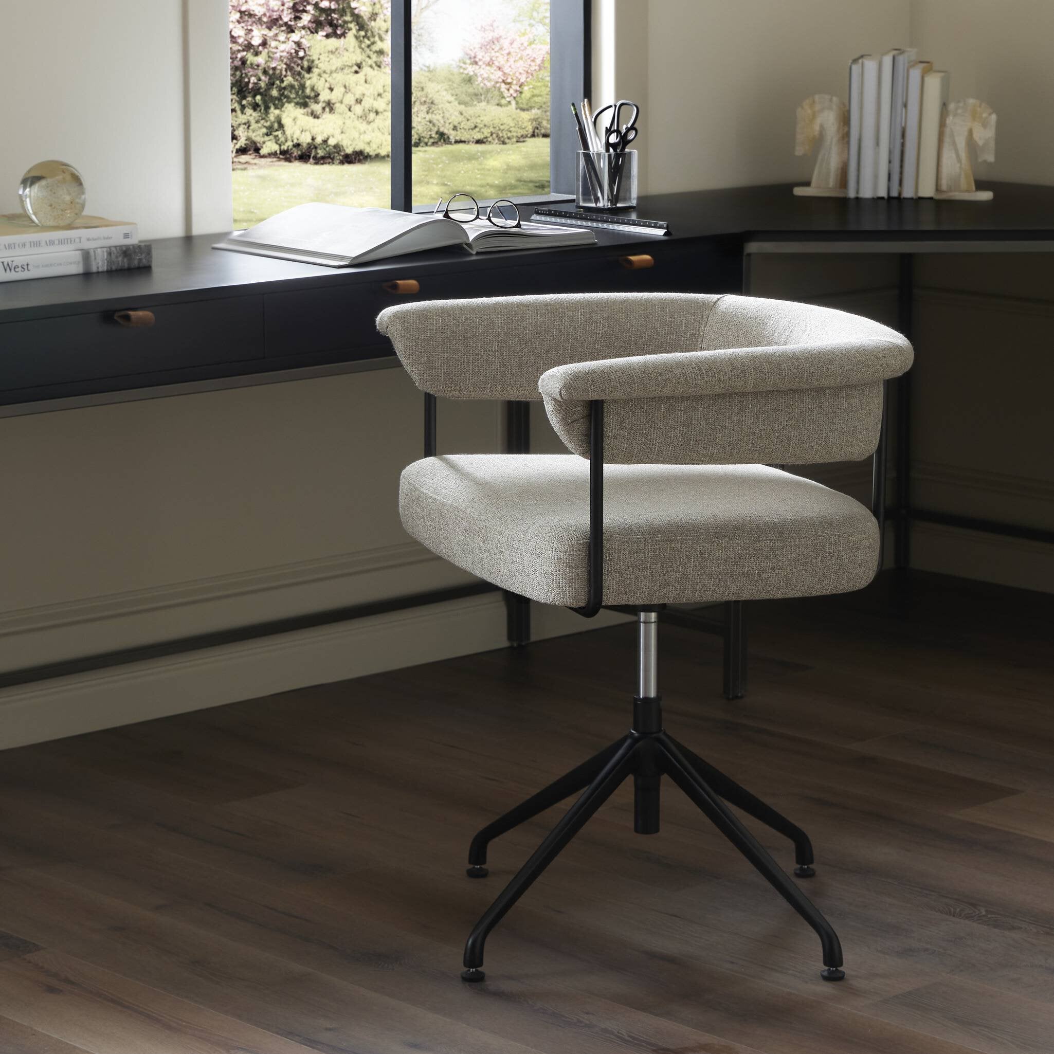 Beige office chair in a modern office setting with a desk and window in the background.