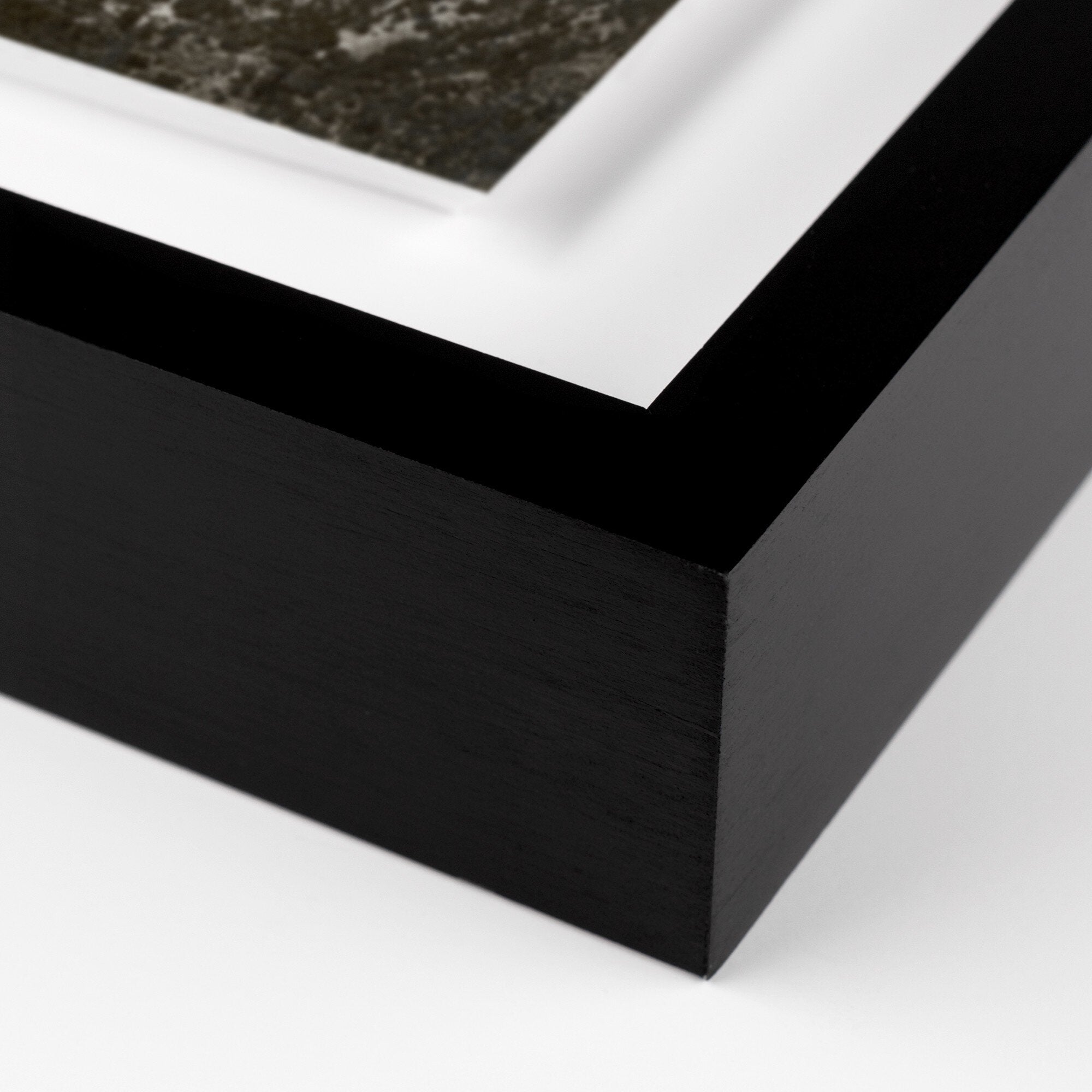 Close-up of a black picture frame corner on a white background